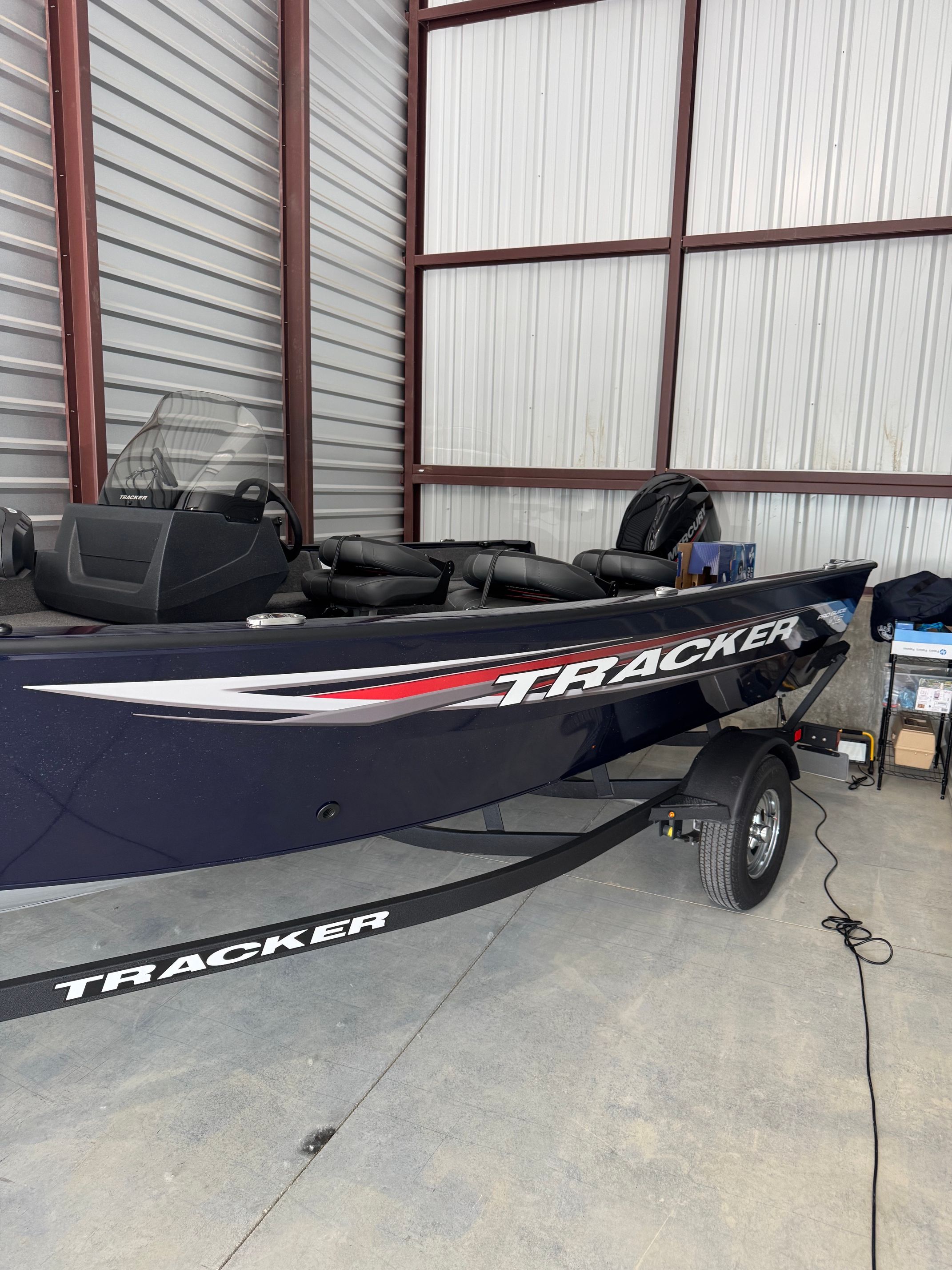 A 2025 Tracker Pro Guide V-16 SC boat is parked in a warehouse.