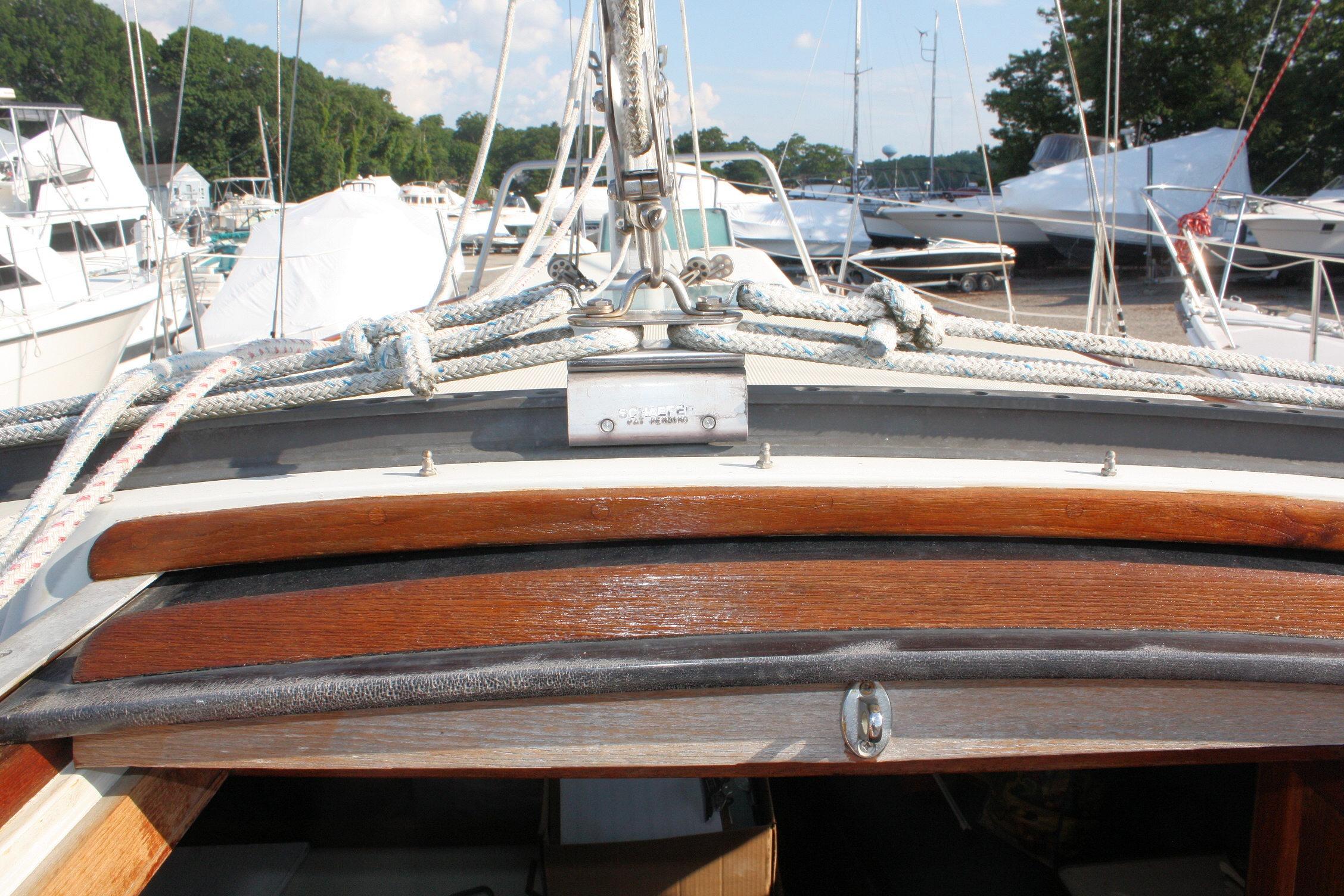 1987 Ericson 38-200 sailboat deck with rigging and wooden hatch in a marina.
