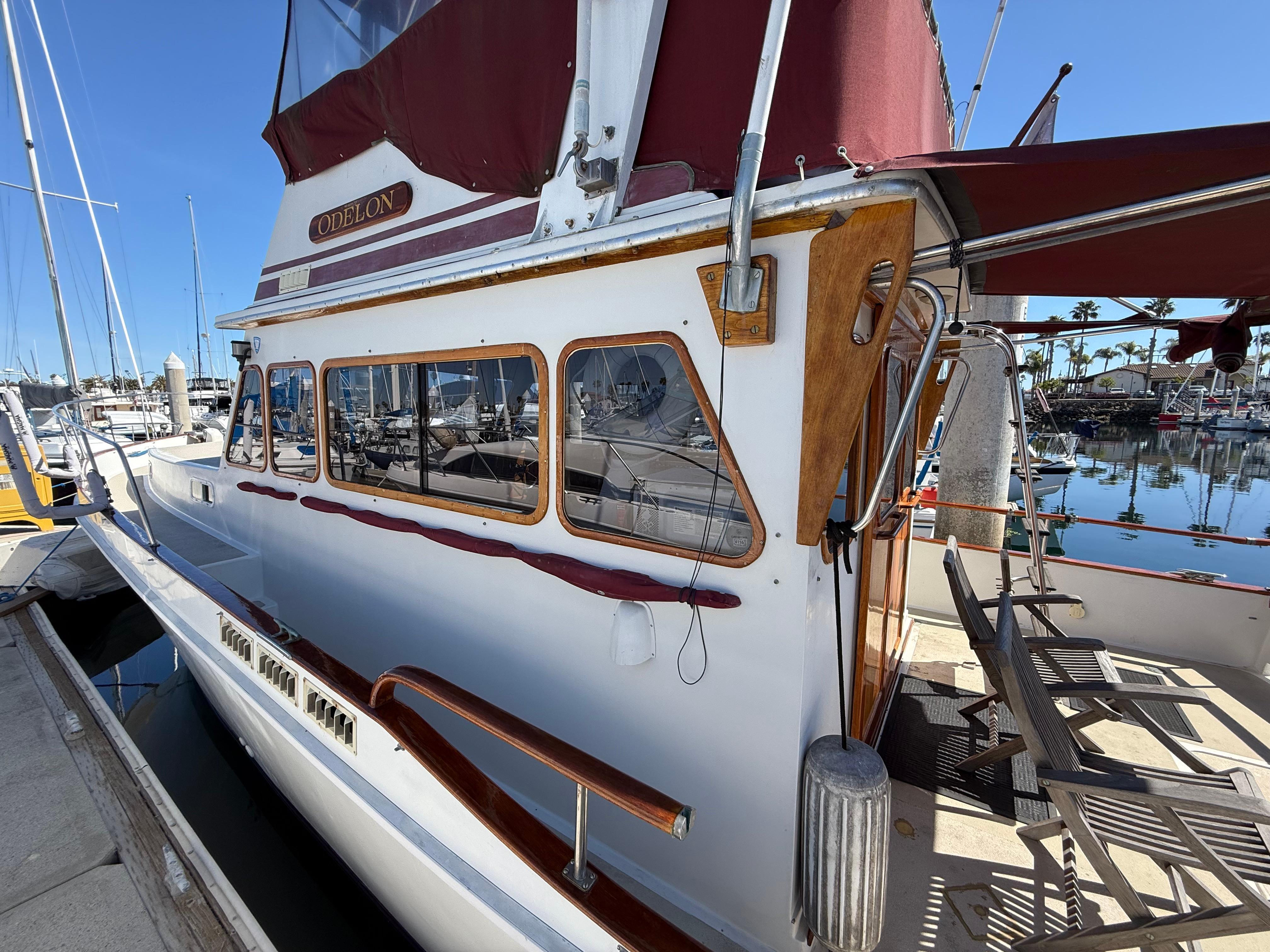1983 Californian 34 yacht docked at marina, featuring classic design and maroon accents.