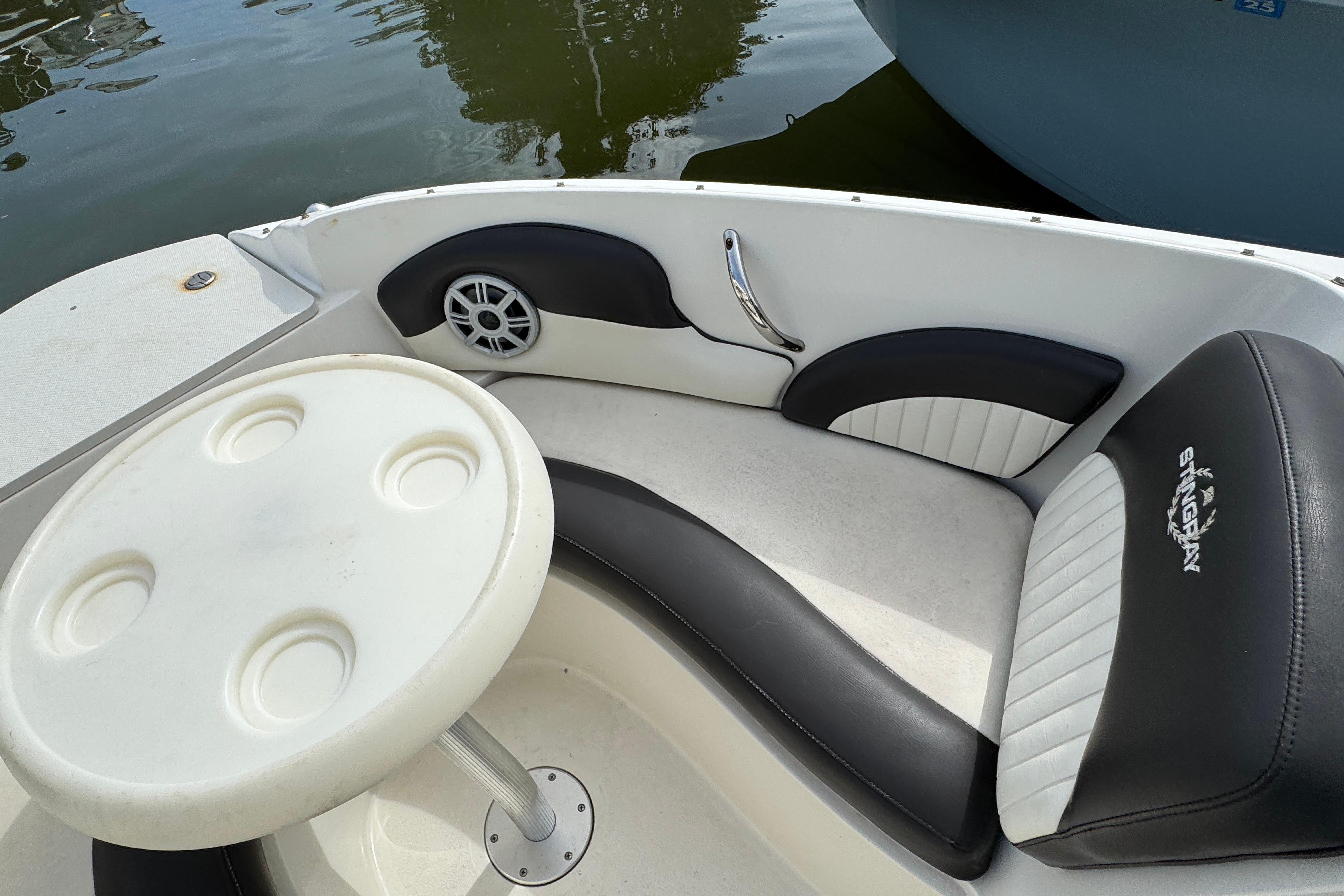 2018 Stingray 204 LR boat interior with seating and table, docked on calm water.