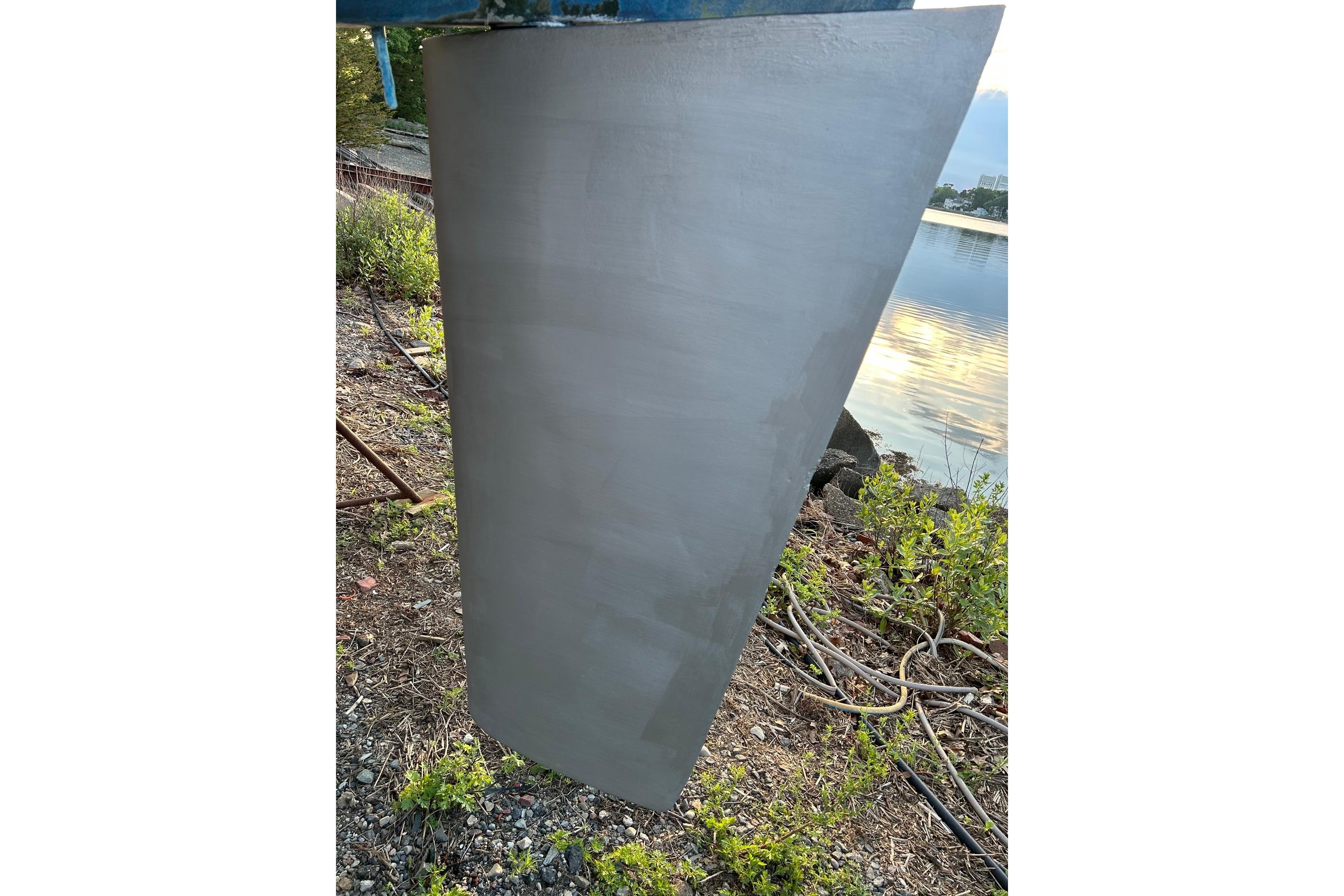 Keel of 1987 Ericson 38-200 sailboat near water, surrounded by greenery.