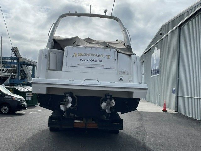 A white yacht on a trailer in front of a building. The name "Argonaut" is visible.