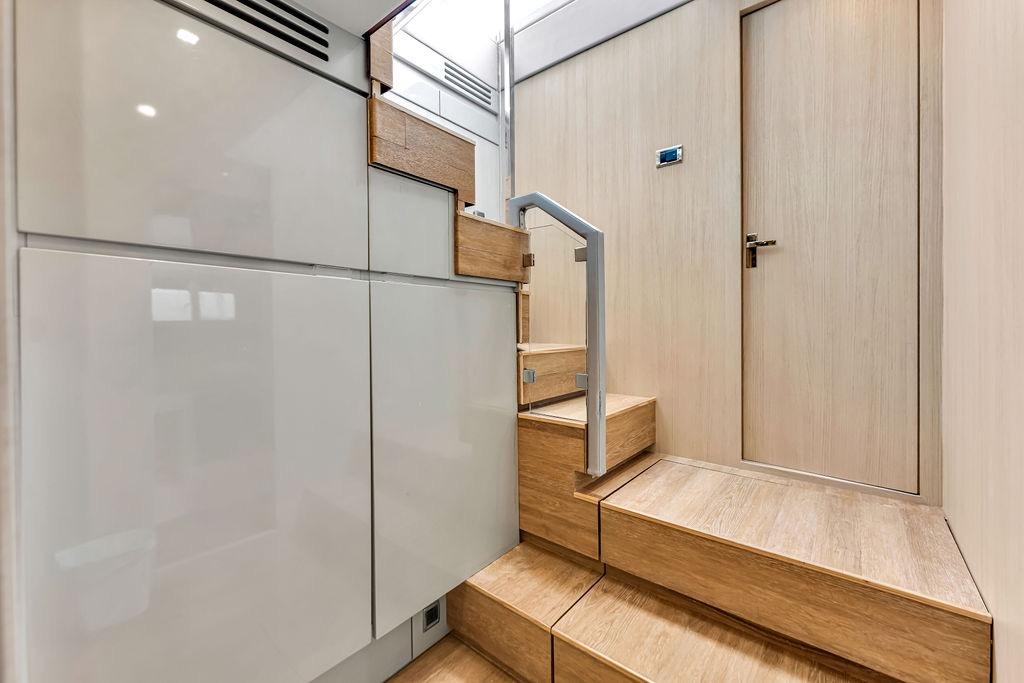 Modern wooden staircase inside 2012 Fairline Targa 58 yacht, featuring sleek design and light wood finish.