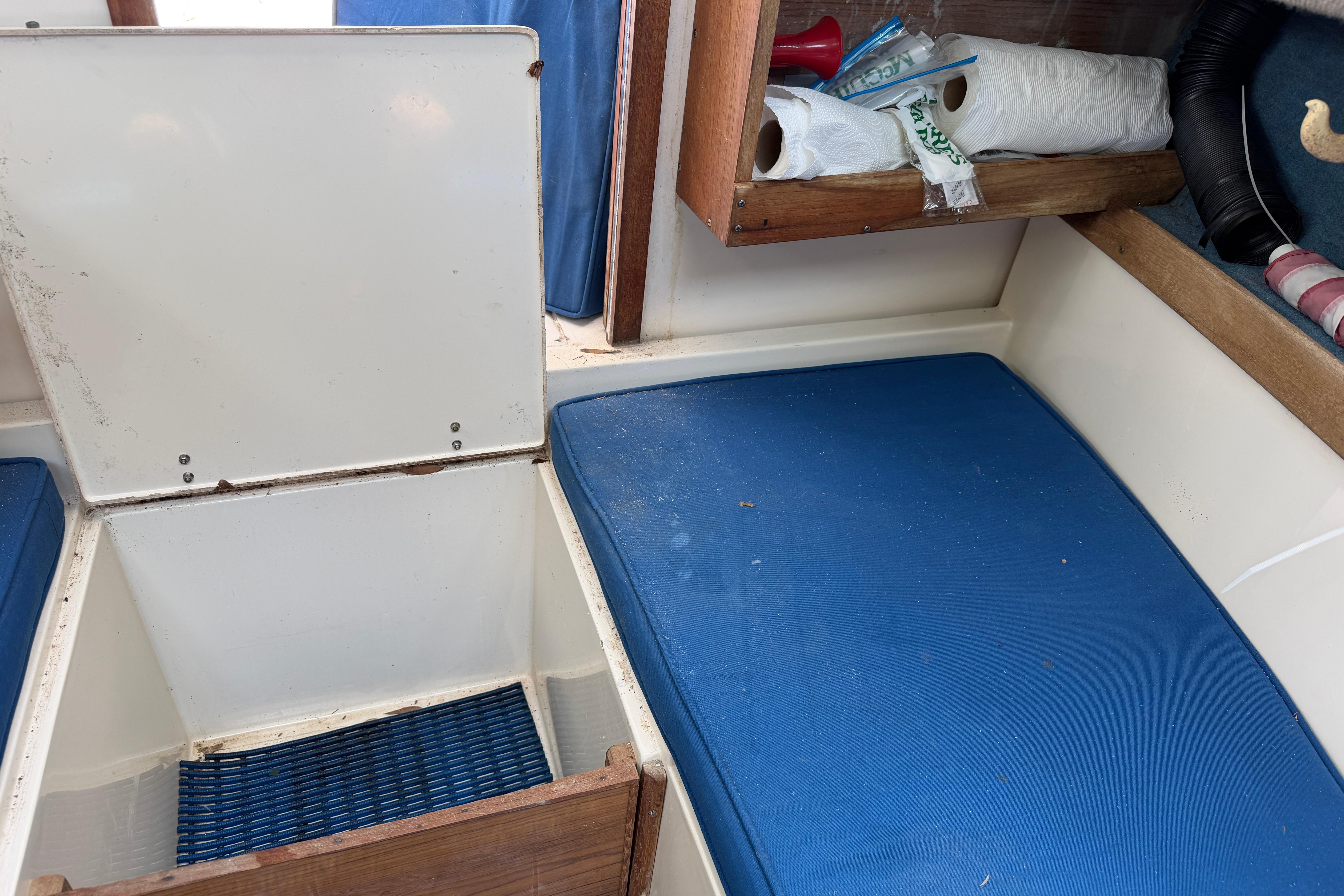 Interior of 1987 Grady-White Seafarer 226 boat with blue cushions and storage compartment.