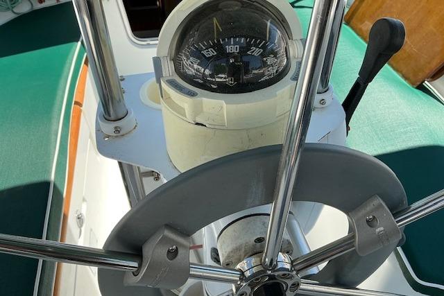 Steering wheel and compass of a 2000 Beneteau Oceanis 321 sailboat.
