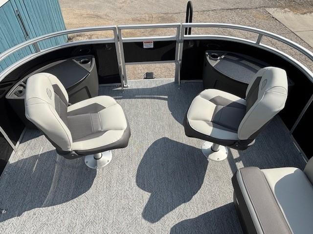 2026 Sun Tracker Fishin' Barge 20 DLX interior with swivel seats and carpeted deck.