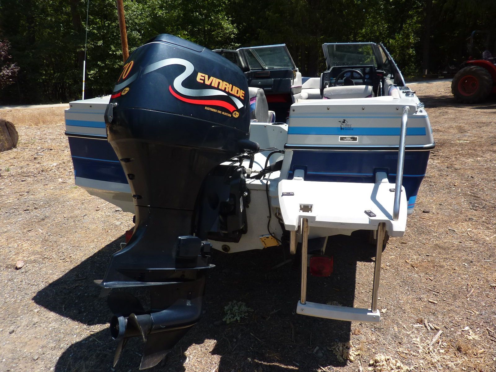A 1989 Bayliner CAPRI with an Evinrude outboard motor, parked on dry land.