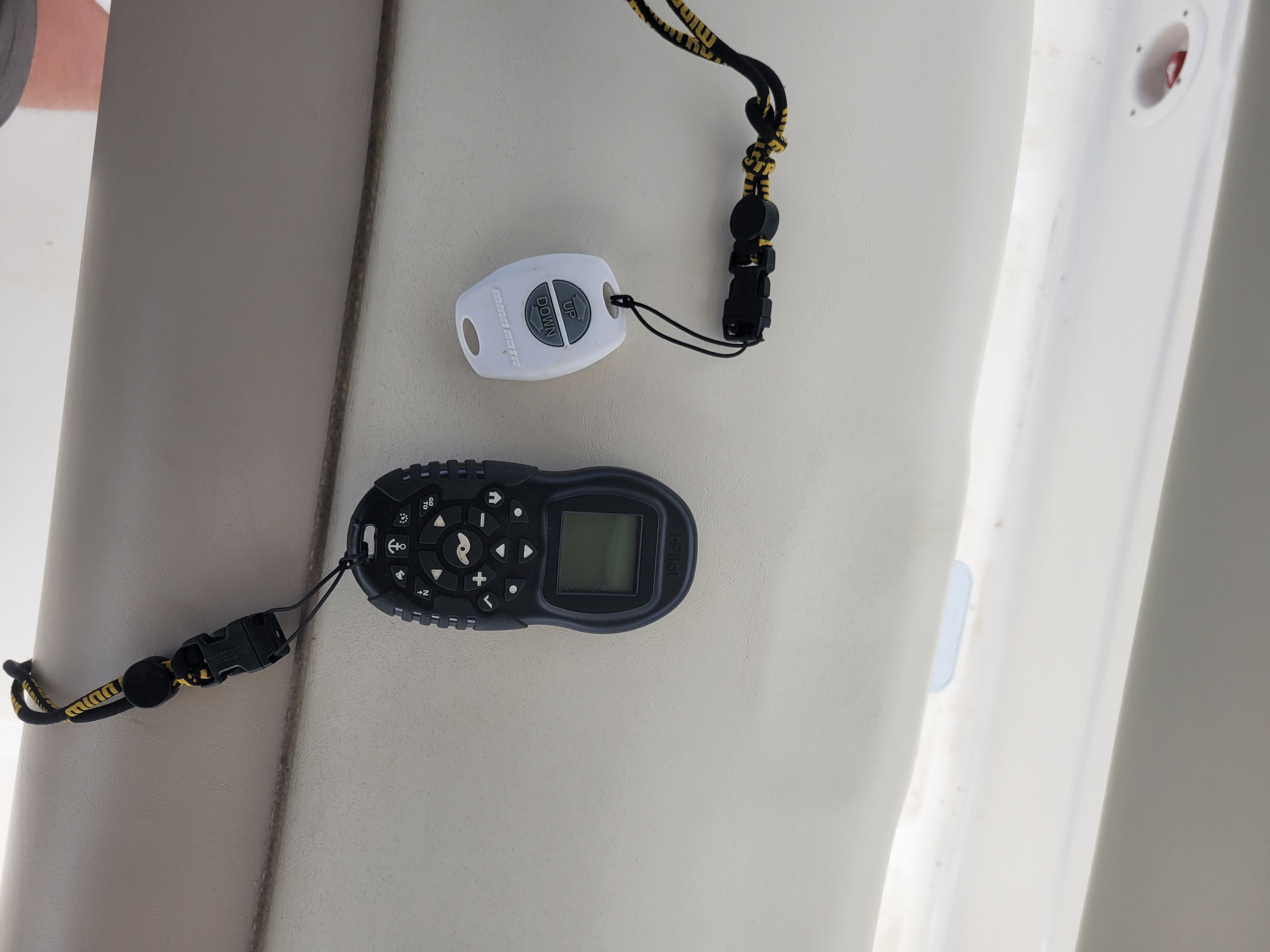 A boat with a remote control and lanyard on a seat.