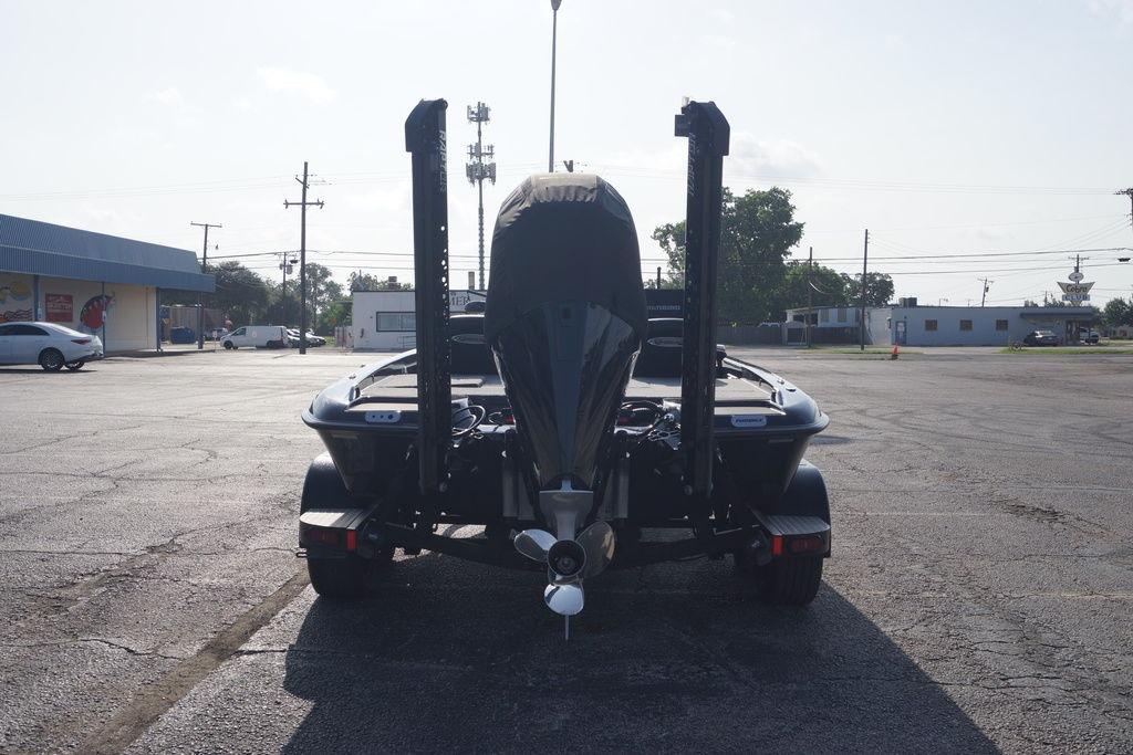 Rear view of a 2025 Phoenix 921 Elite boat on a trailer in a parking lot.