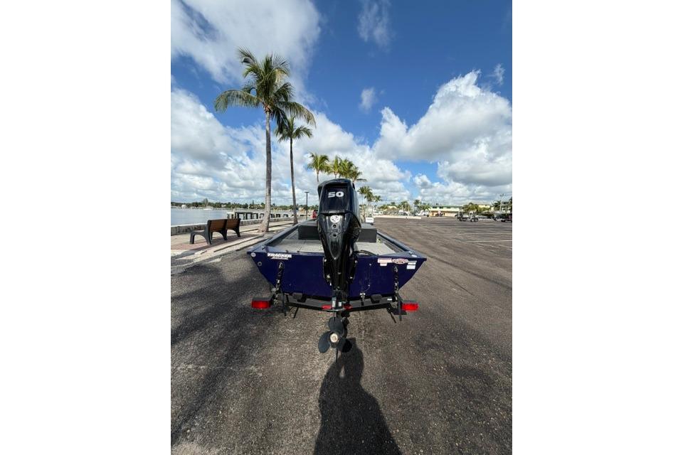 2020 Tracker Pro 170 boat on trailer, parked near waterfront with palm trees.