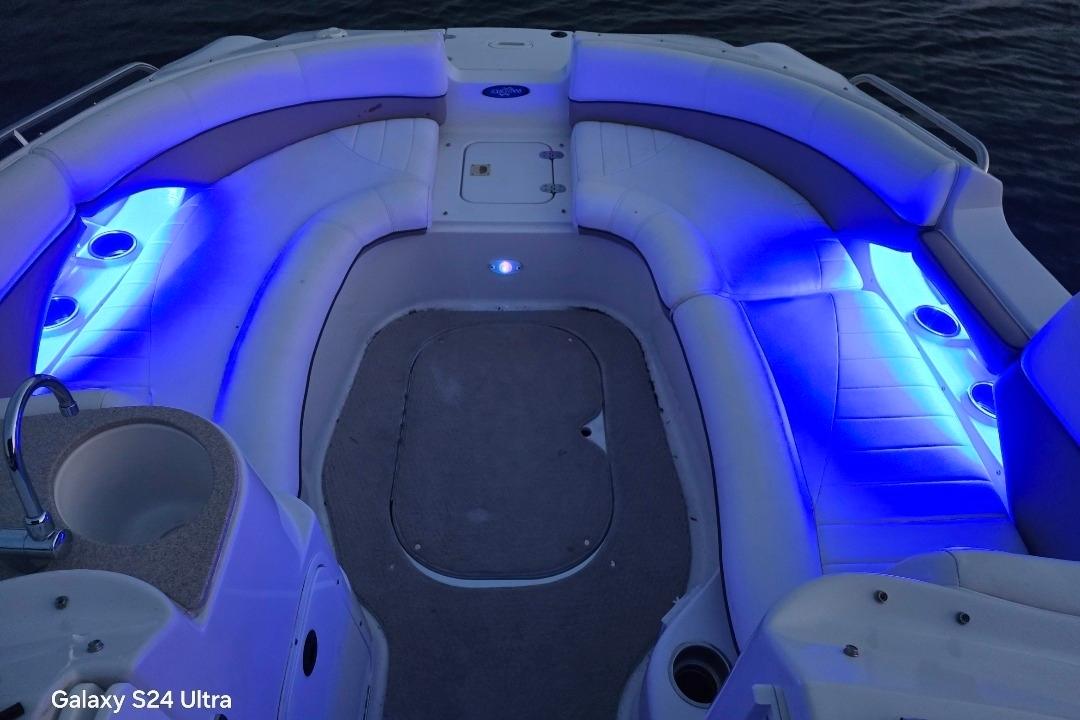 2006 Four Winns 244 Funship boat interior with blue LED lighting and cushioned seating.