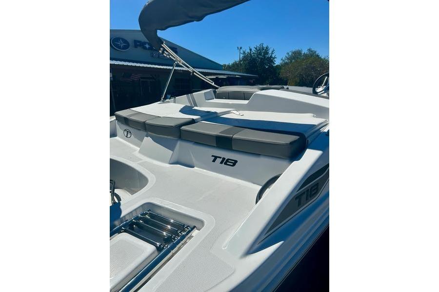2025 Tahoe T18 boat with cushioned seating and sleek design under a clear blue sky.