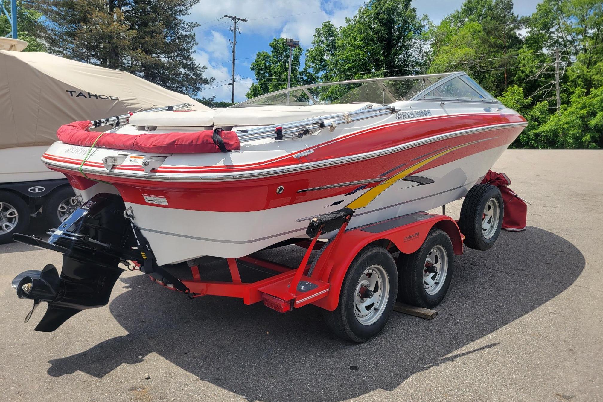 2007 Four Winns 200 Horizon boat on a red trailer, parked outdoors.