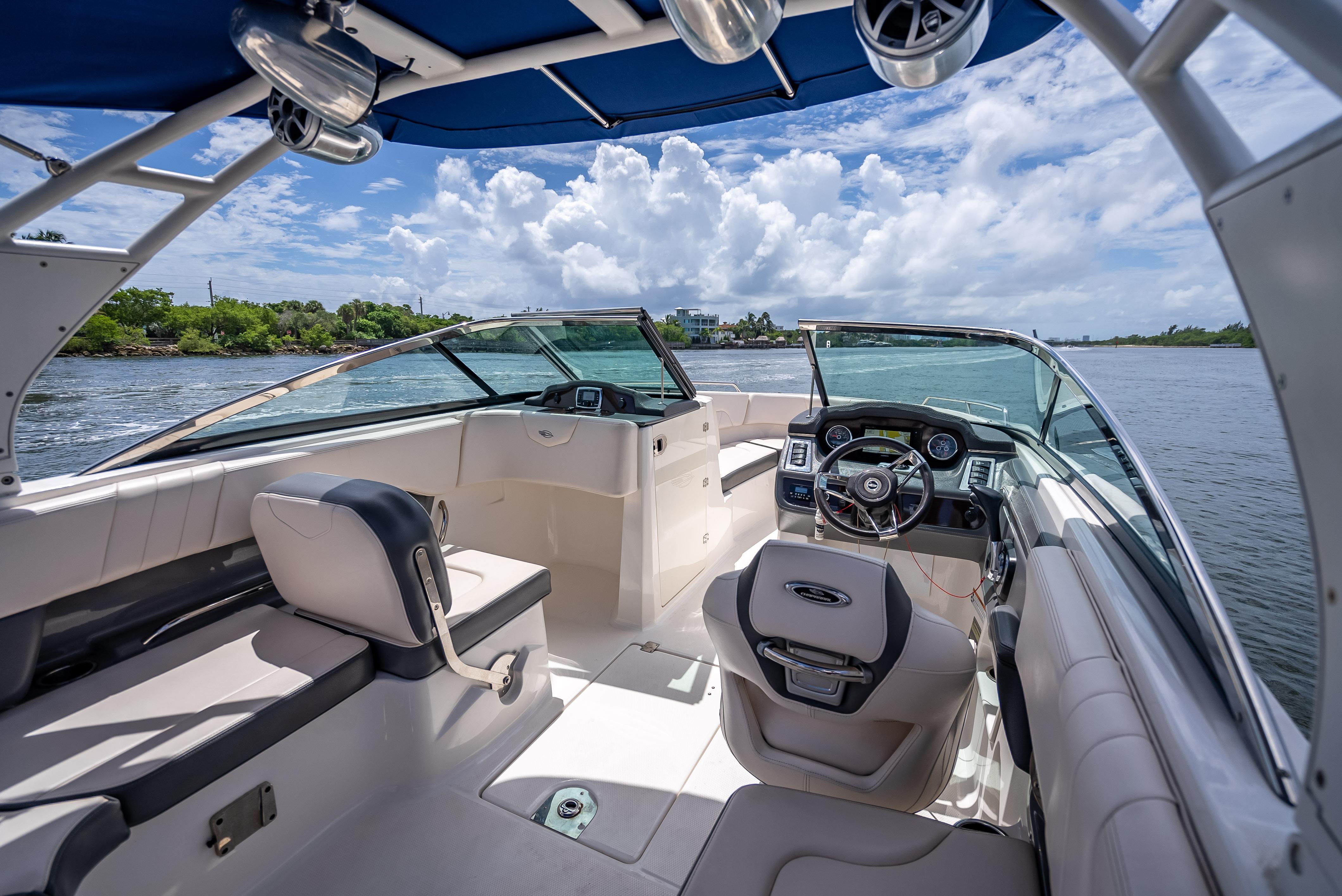2017 Chaparral 227 SSX boat interior with steering wheel, seating, and blue canopy.