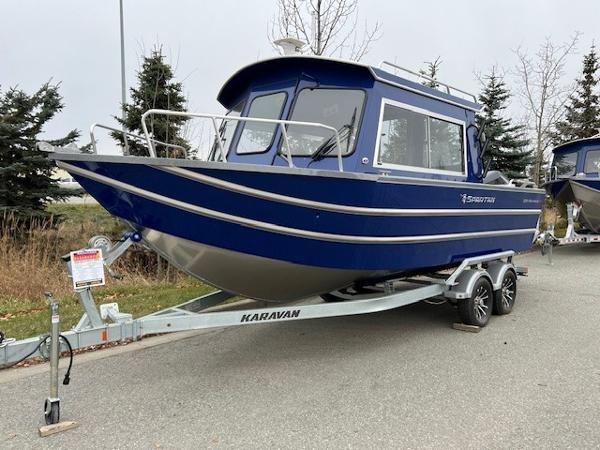2023 Spartan 220 Maximus Pro boat on Karavan trailer, parked outdoors.