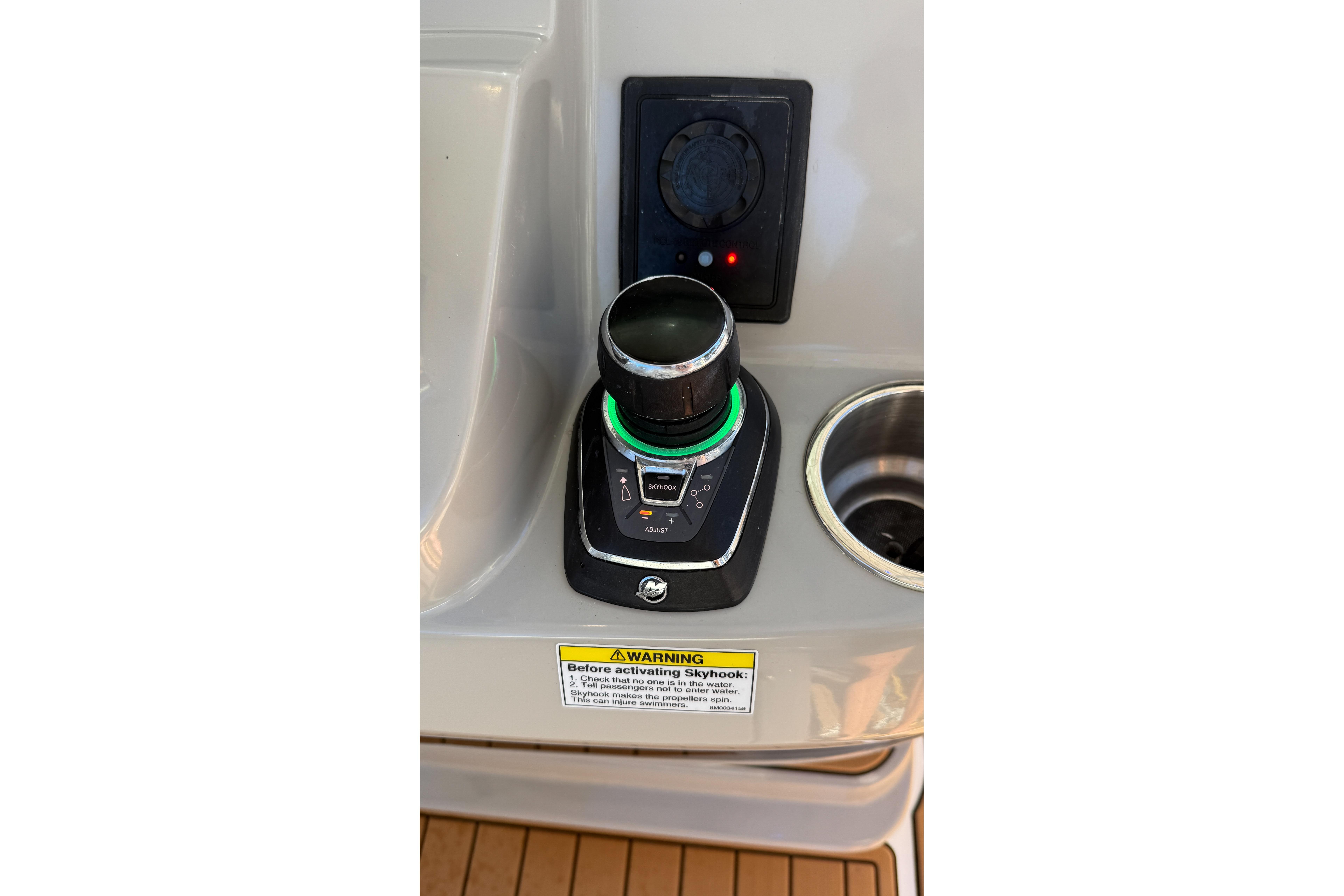 Control panel of a 2017 Boston Whaler 370 Outrage boat with joystick and warning label.