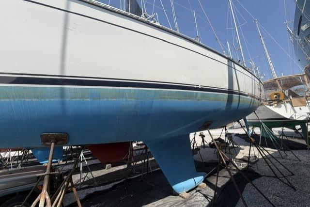2002 Saga 43 sailboat on stands, blue hull, in a boatyard.