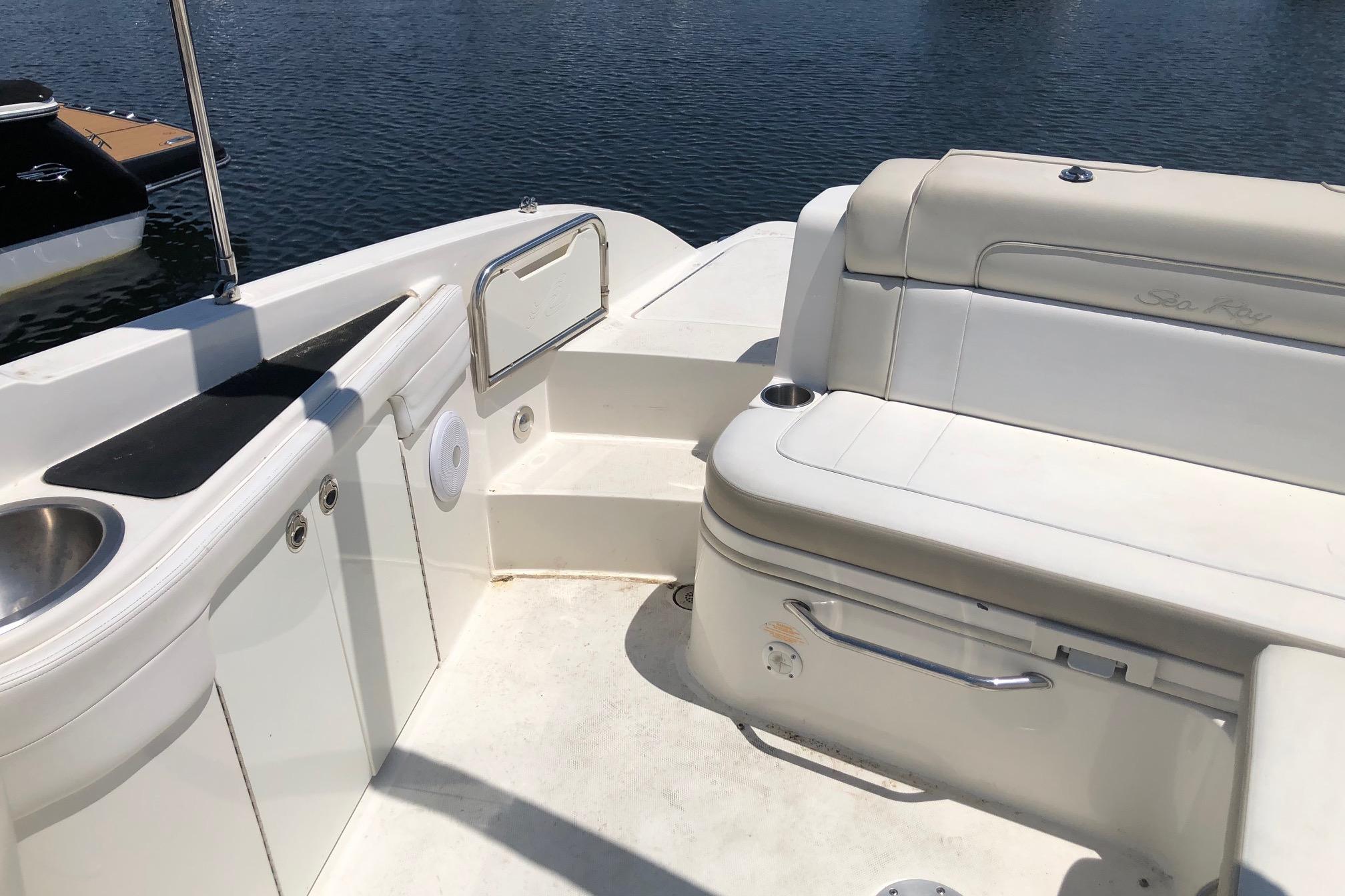 2013 Sea Ray 260 Sundeck interior with seating and sink, docked by the water.