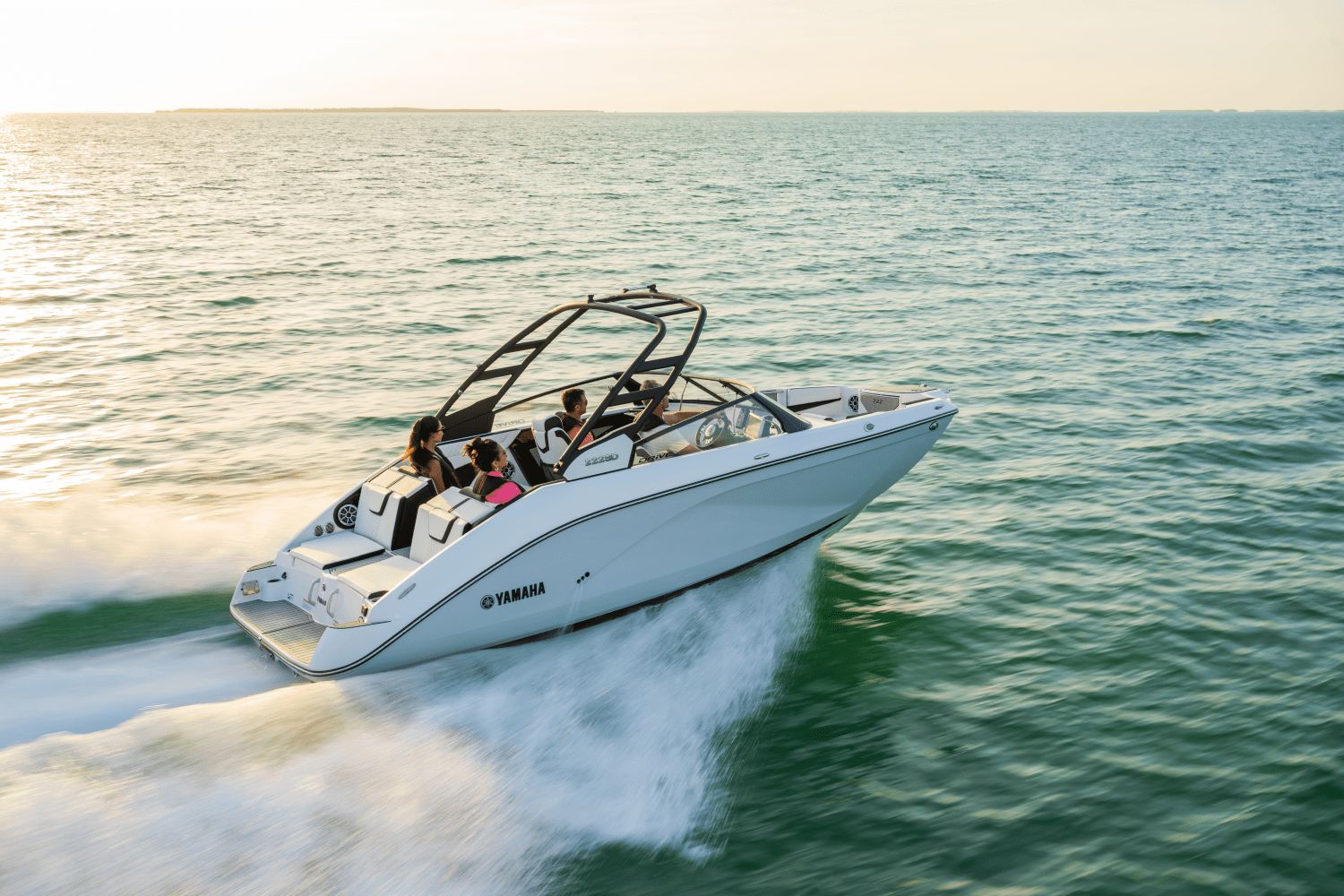 Yamaha 222SD boat from 2026 speeding over calm water at sunset.