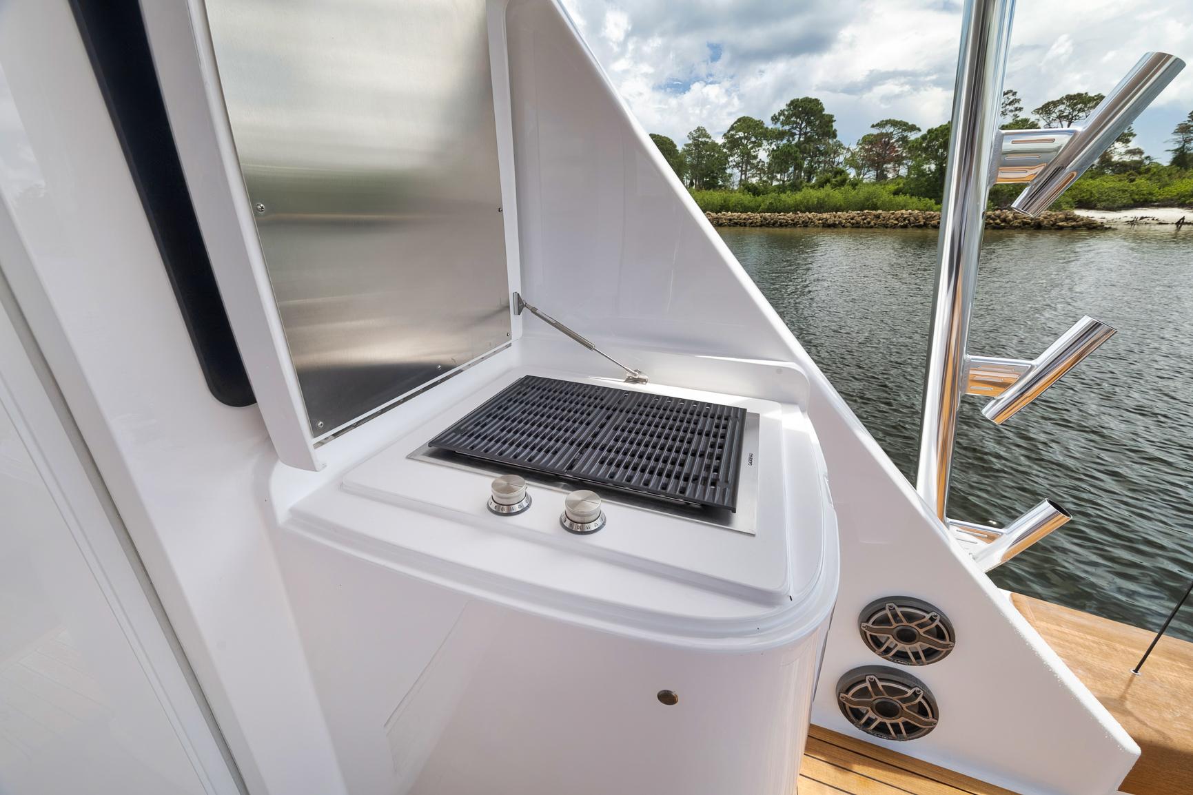 Outdoor grill on 2024 Viking 72 Convertible yacht, with scenic water view.