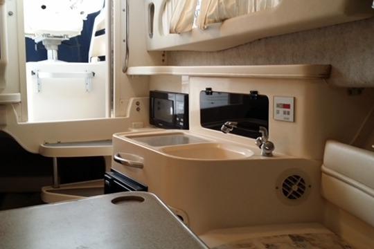 Interior of 2002 Grady-White Marlin 300 boat with kitchenette and seating area.