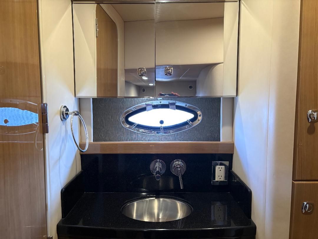 The image shows an elegant boat bathroom with a round sink and a mirror.