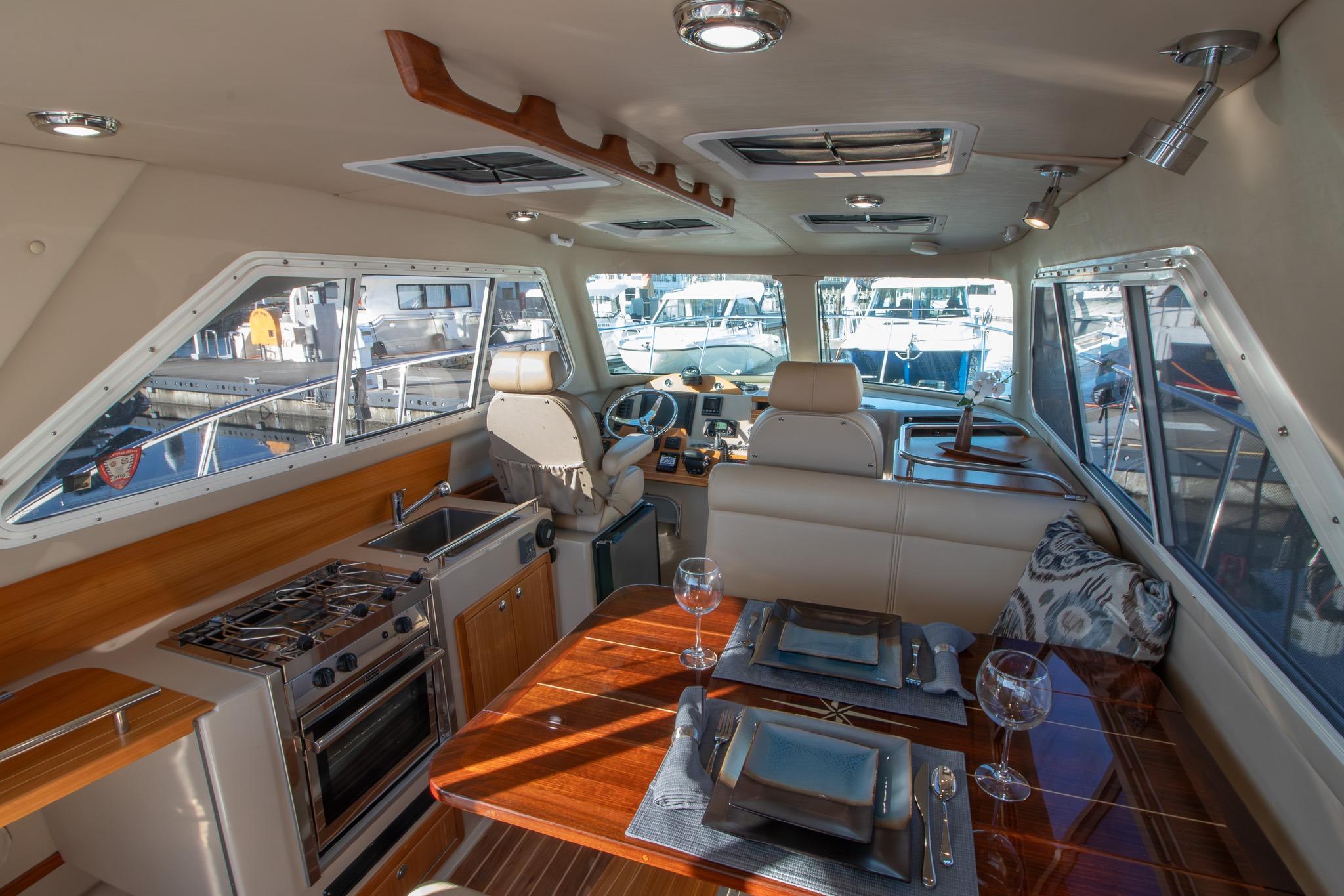 Luxurious interior of 2016 Aspen C100 yacht with dining area and helm station.
