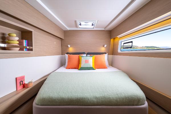 Luxurious bedroom interior of 2025 Lagoon 43 yacht with modern decor and large window view.
