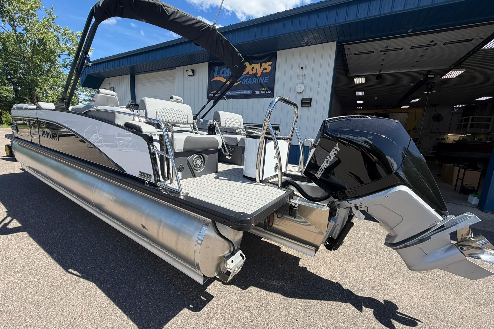 2026 Avalon Catalina Quad Lounge Shift pontoon boat with Mercury outboard motor, docked outdoors.