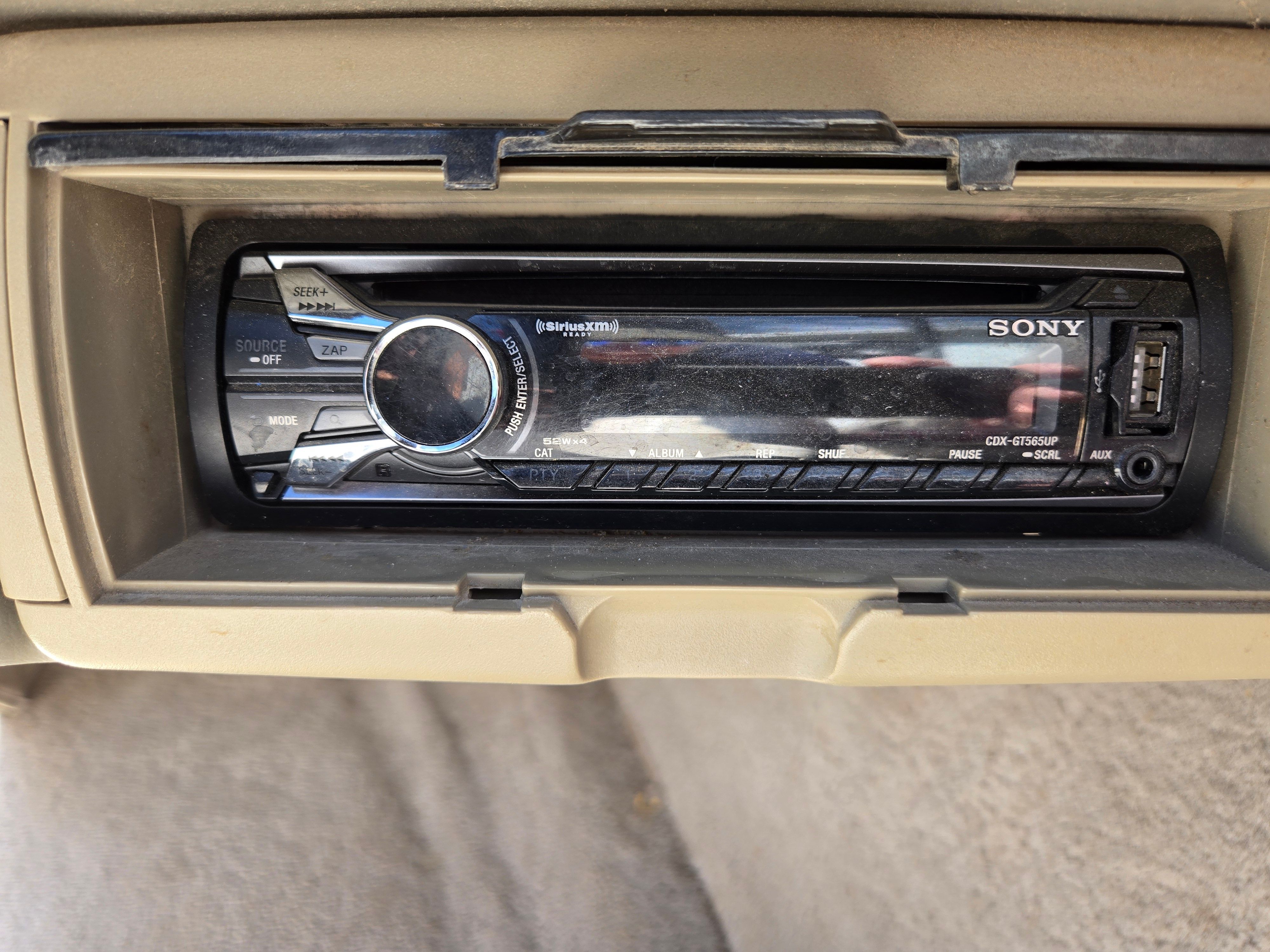 A Sony car stereo is installed in a beige dashboard.