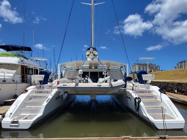 2009 Catana 65 catamaran docked at a marina under a clear blue sky.
