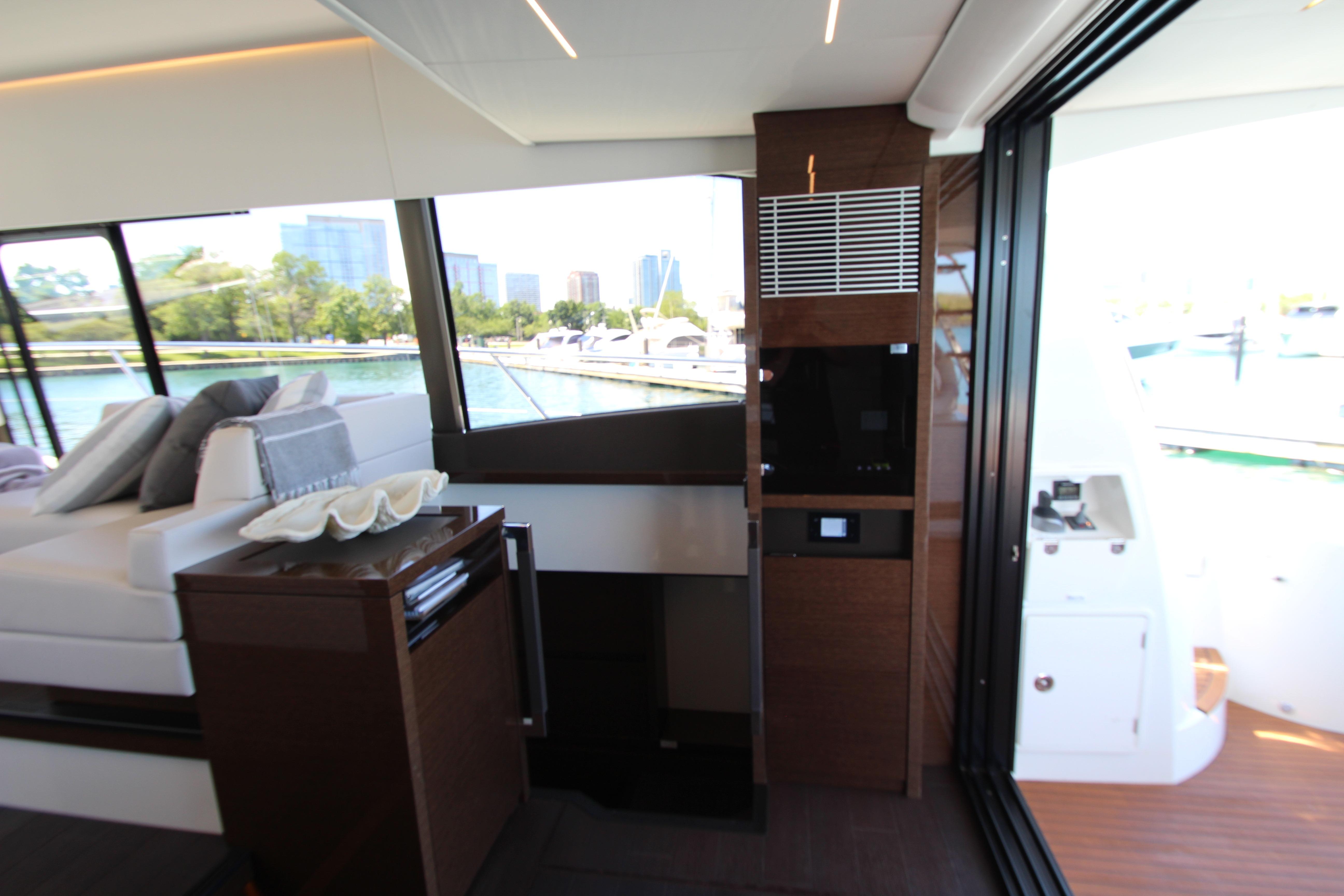 Luxurious interior of 2022 Prestige 520 yacht with modern furnishings and large windows.
