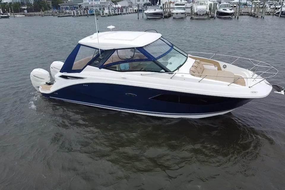 2021 Sea Ray Sundancer 320 Outboard cruising on a calm marina.