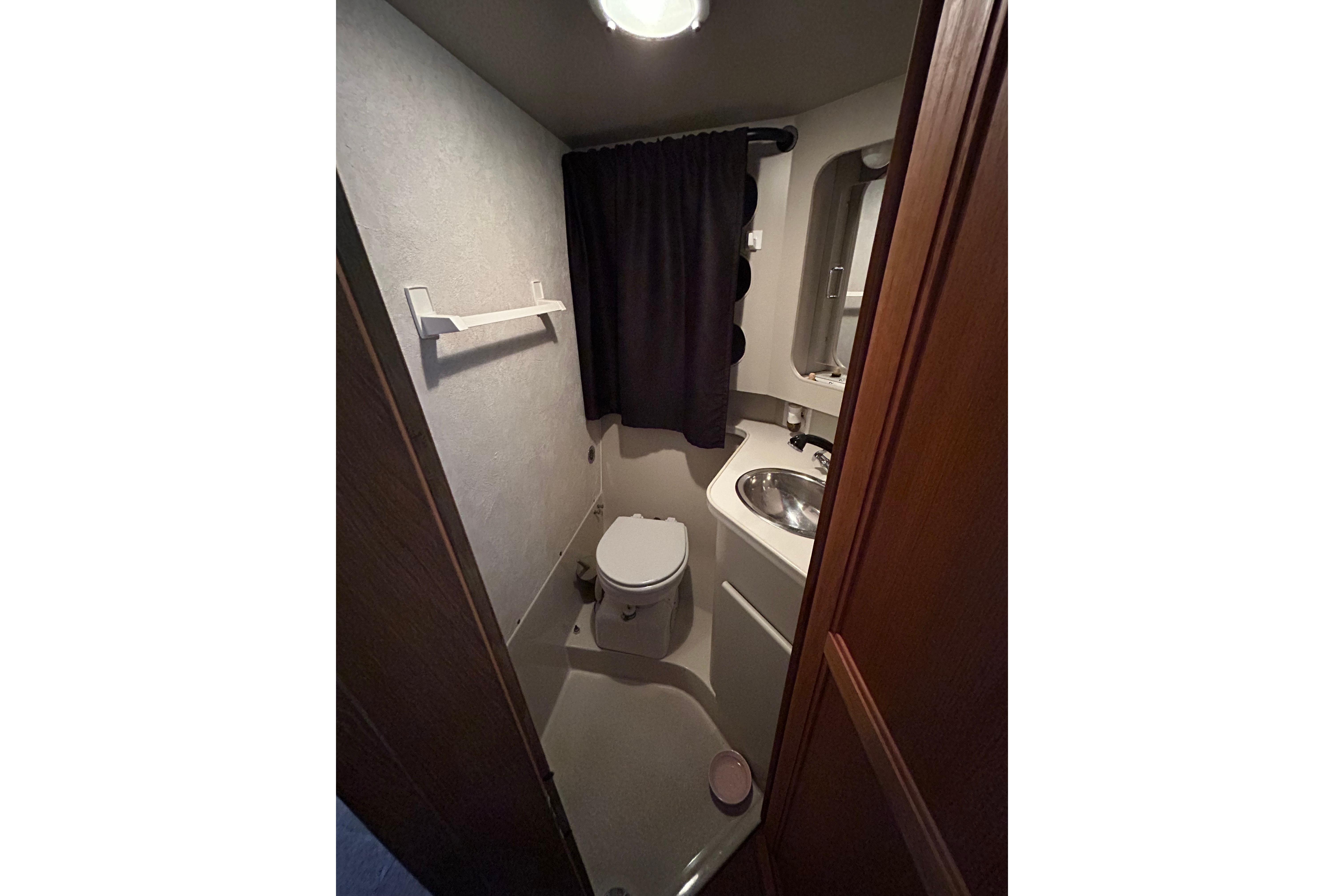 Bathroom interior of 1991 Carver 3608 Aft Cabin Motor Yacht, featuring toilet and sink.