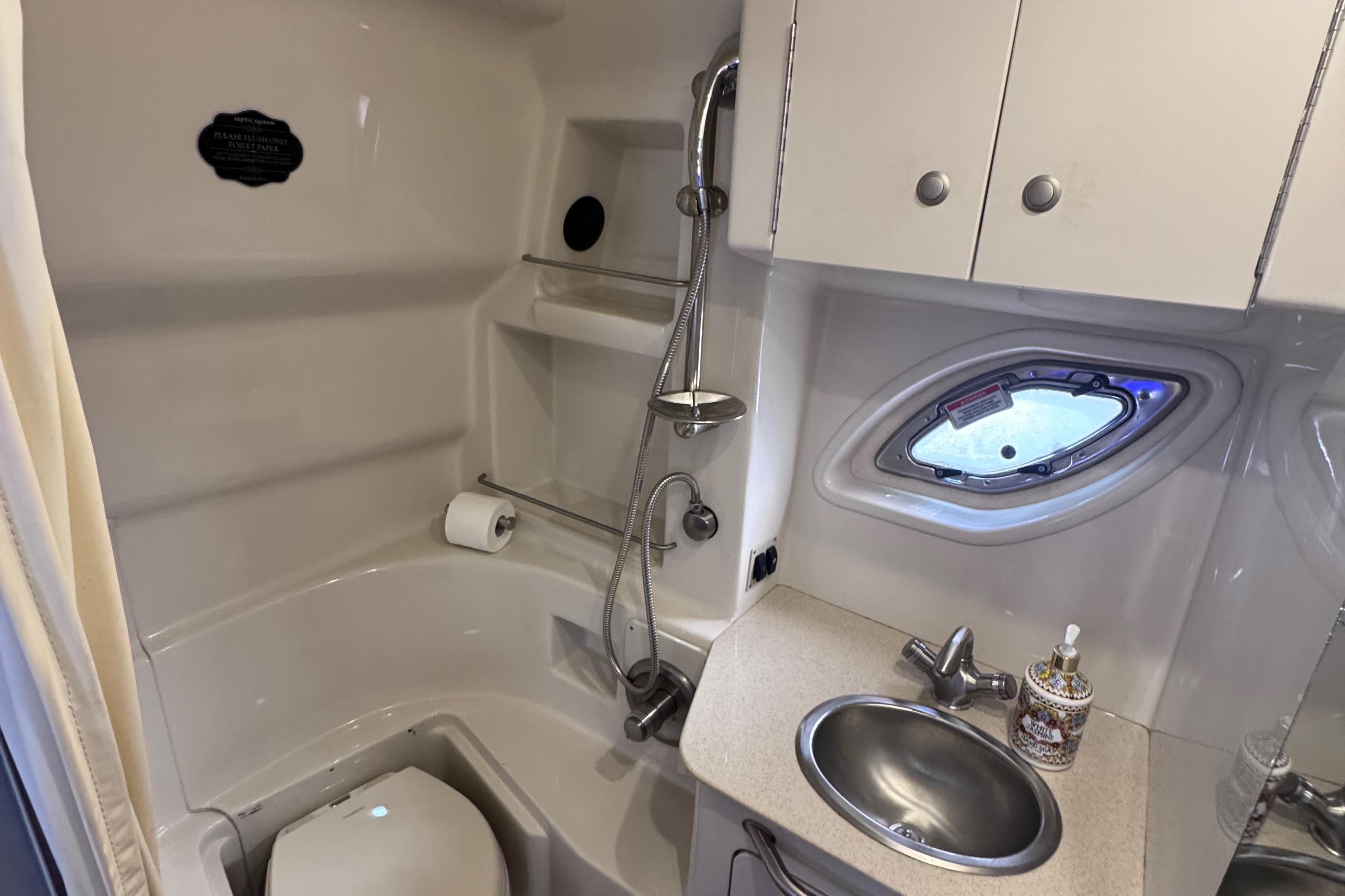 2008 Sea Ray 350 Sundancer bathroom with shower, sink, and porthole window.