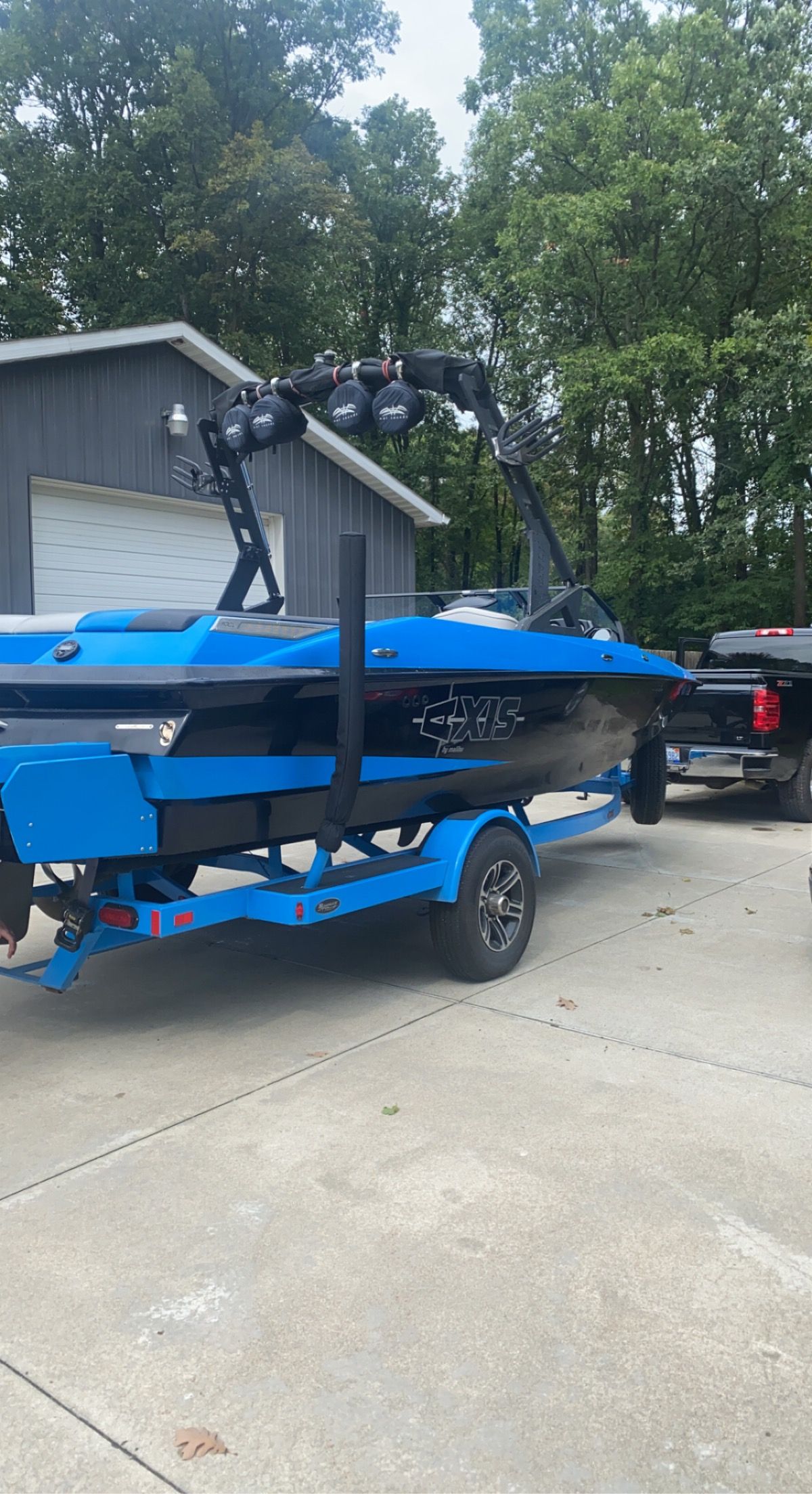 2015 Malibu Axis A20 boat on trailer in front of garage.