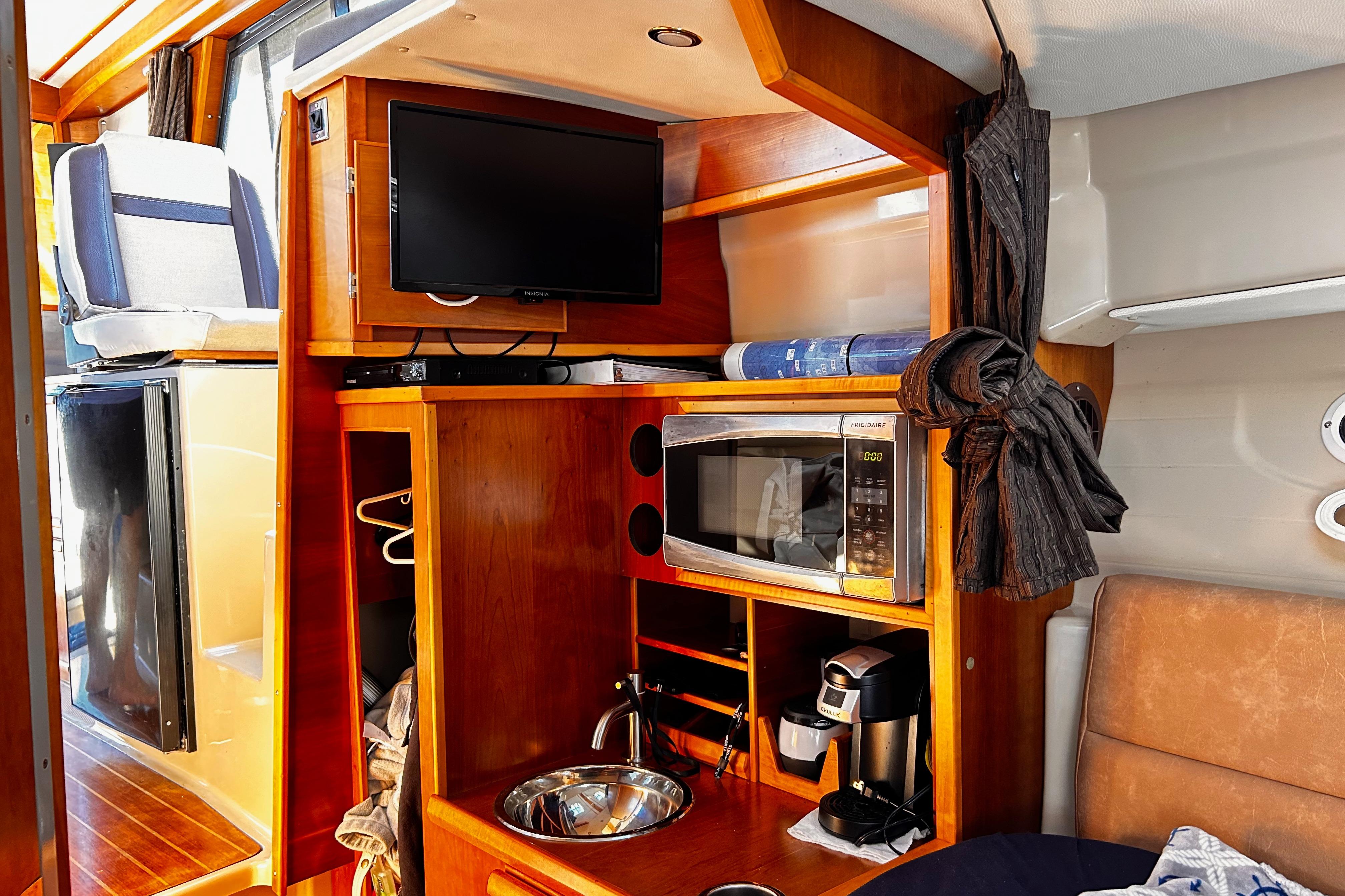 2014 Cutwater C-28 interior with TV, microwave, and coffee maker in wooden cabinetry.