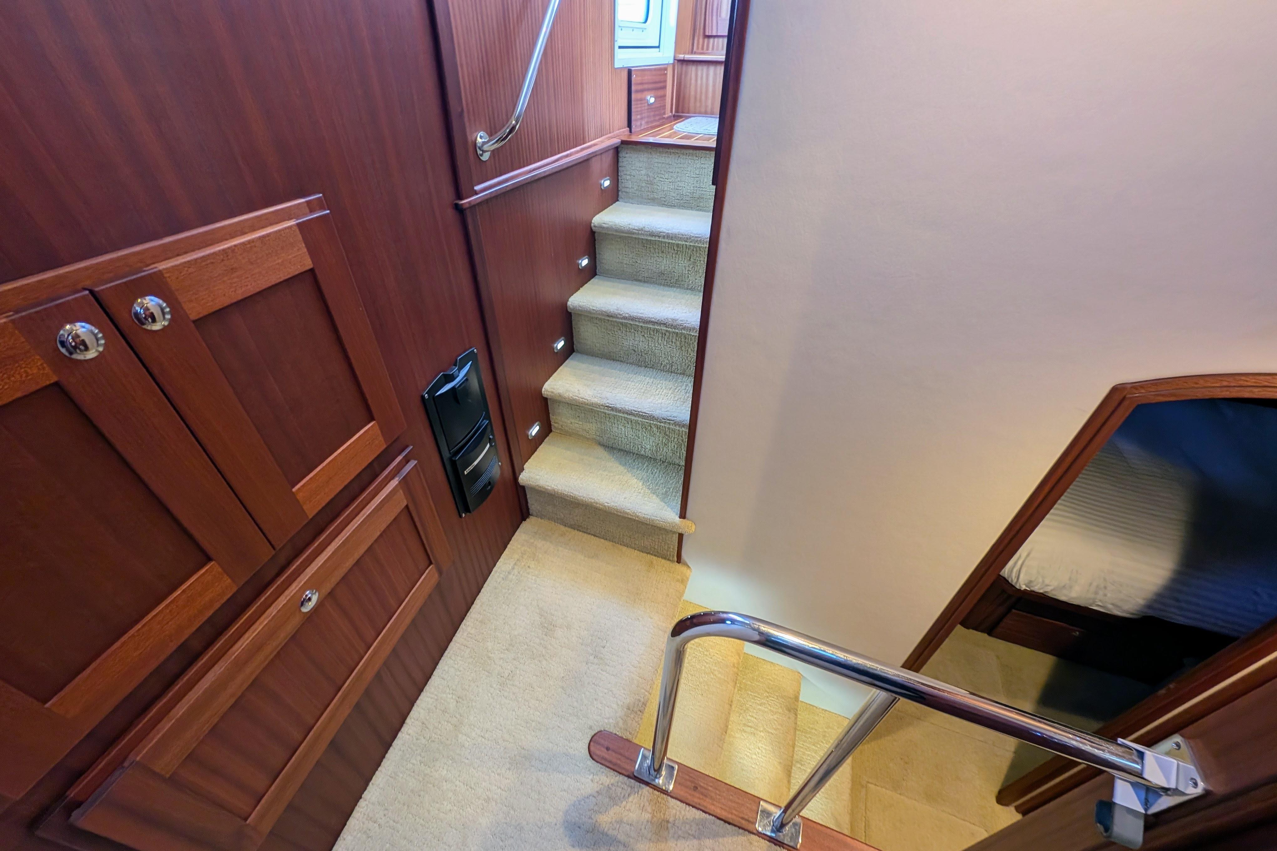 Staircase and cabin interior of 2015 American Tug 435 yacht, featuring wood paneling.