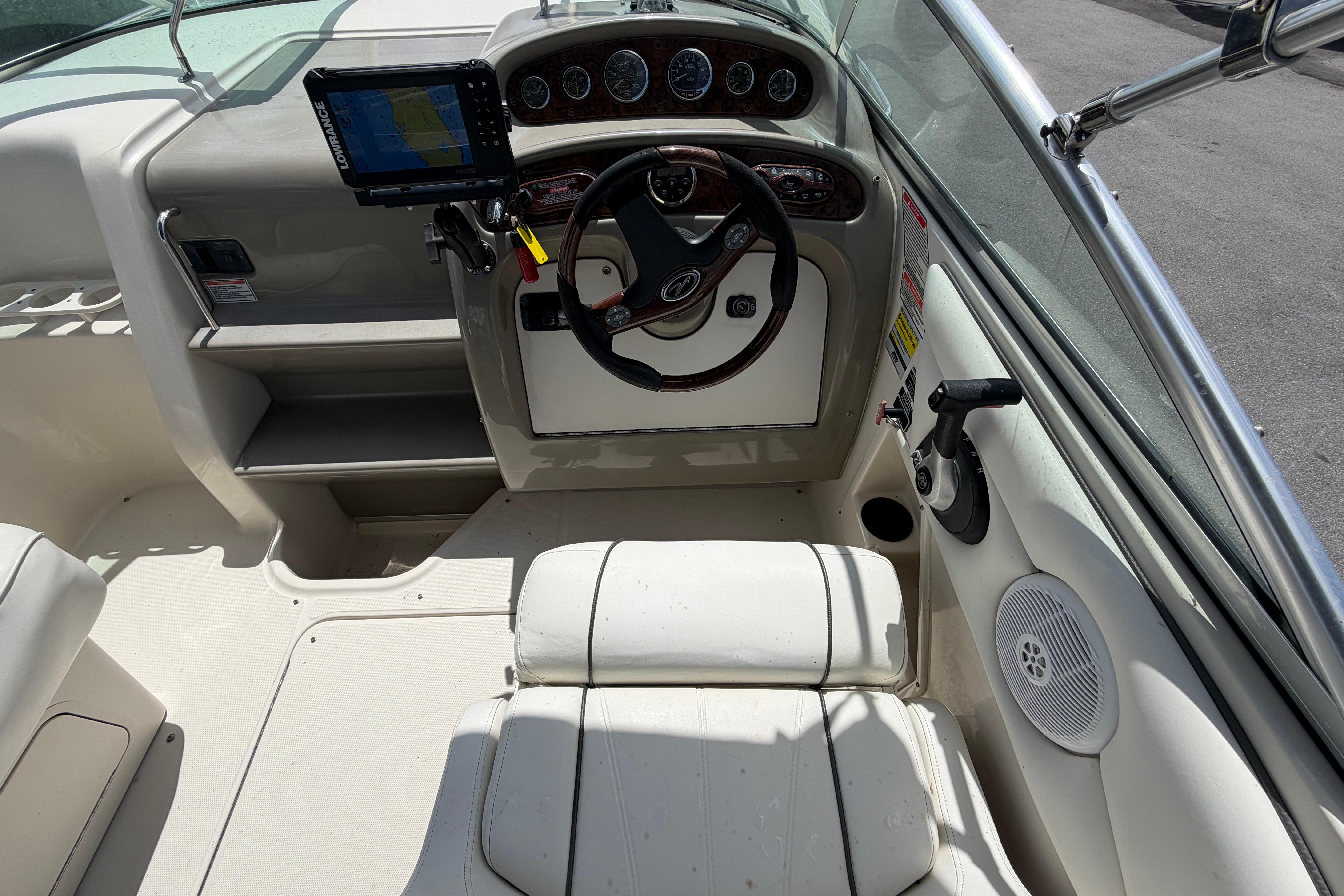 2006 Sea Ray 250 Amberjack boat cockpit with steering wheel and navigation system.