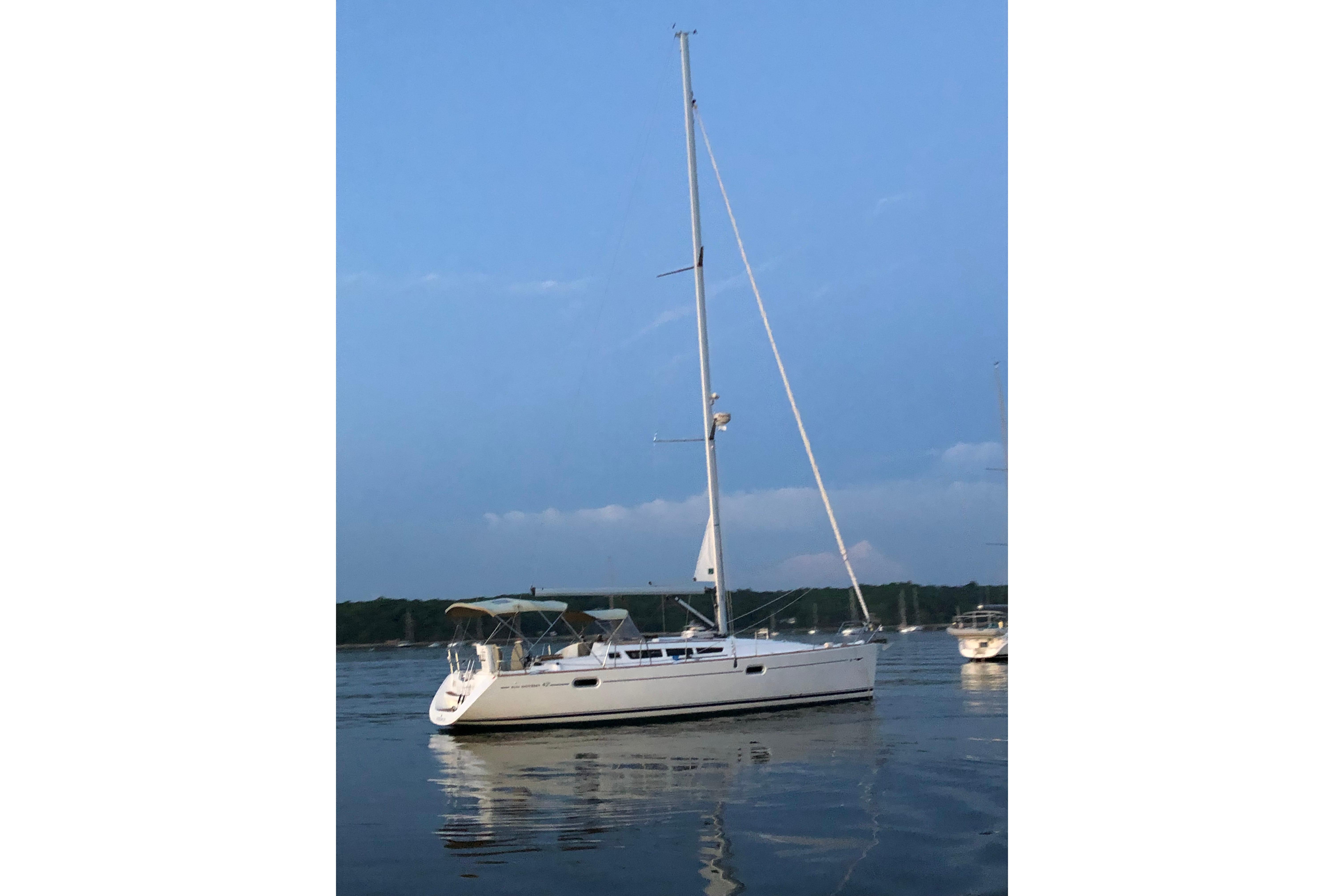 2007 Jeanneau Sun Odyssey 42i sailboat on calm water at sunset.