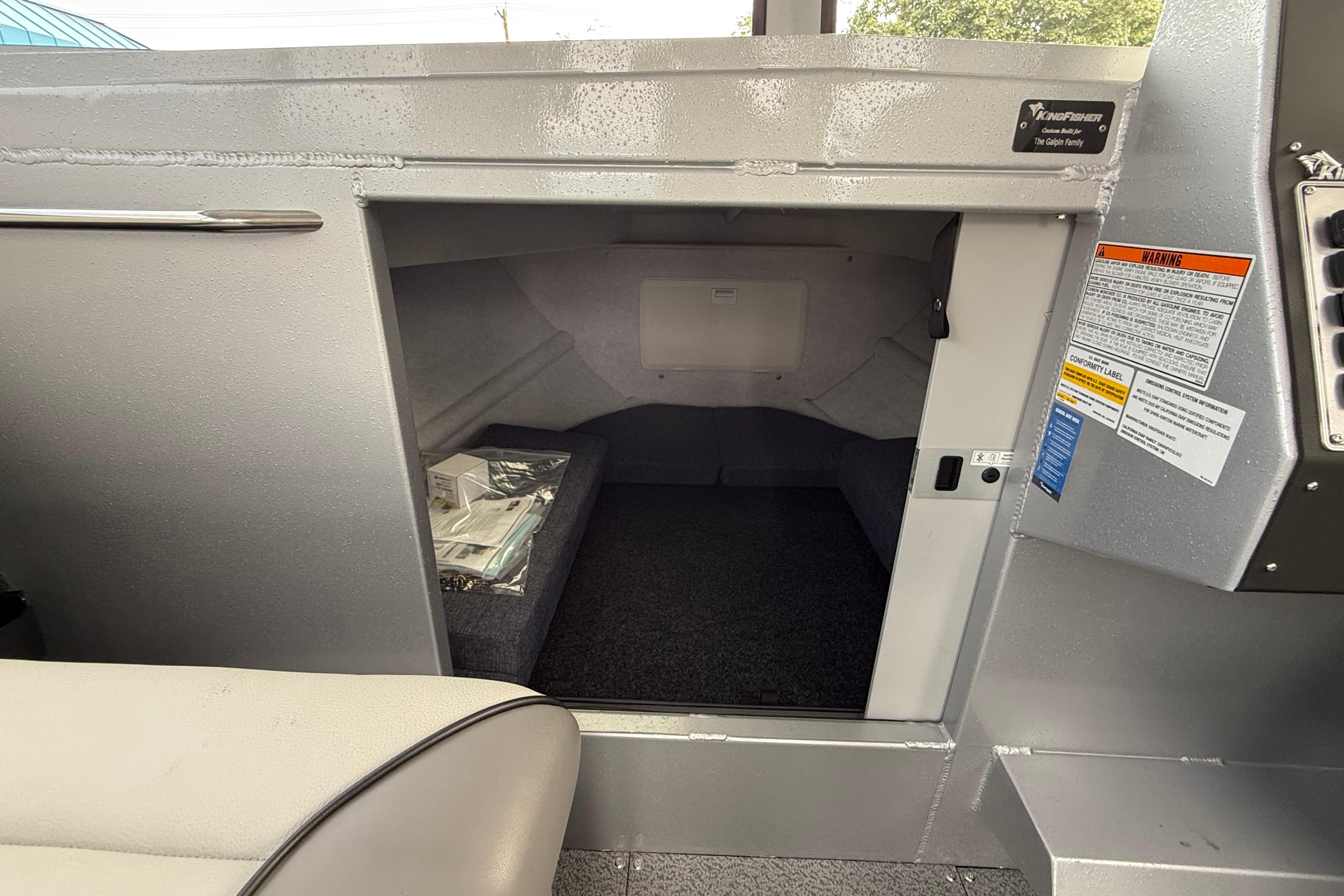 Interior cabin of 2026 KingFisher 25 XAC boat, featuring compact storage space.
