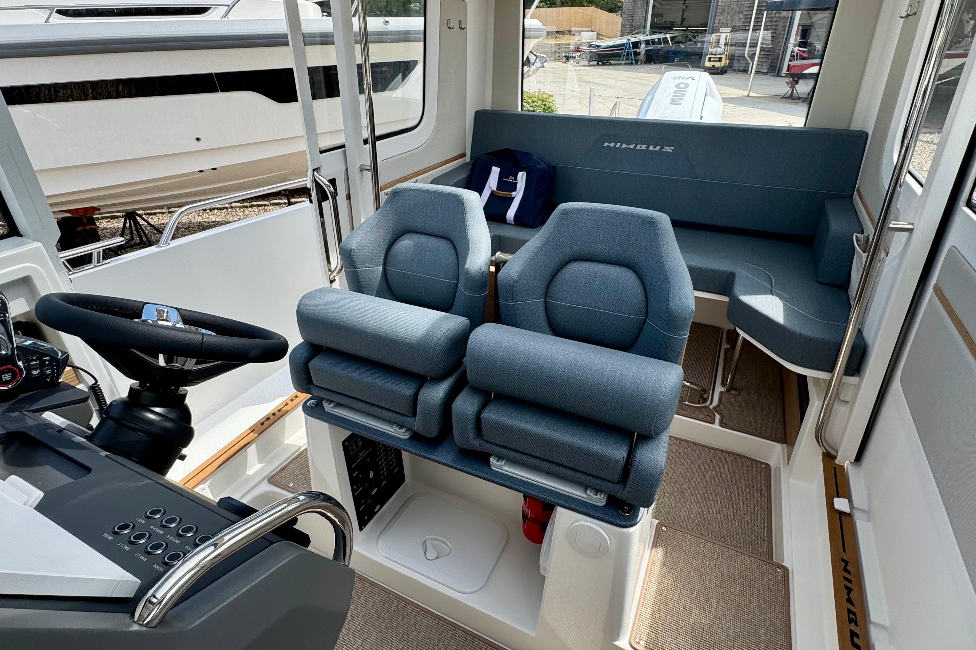 Interior of the Nimbus Commuter 9 with two cushioned seats and a helm station.