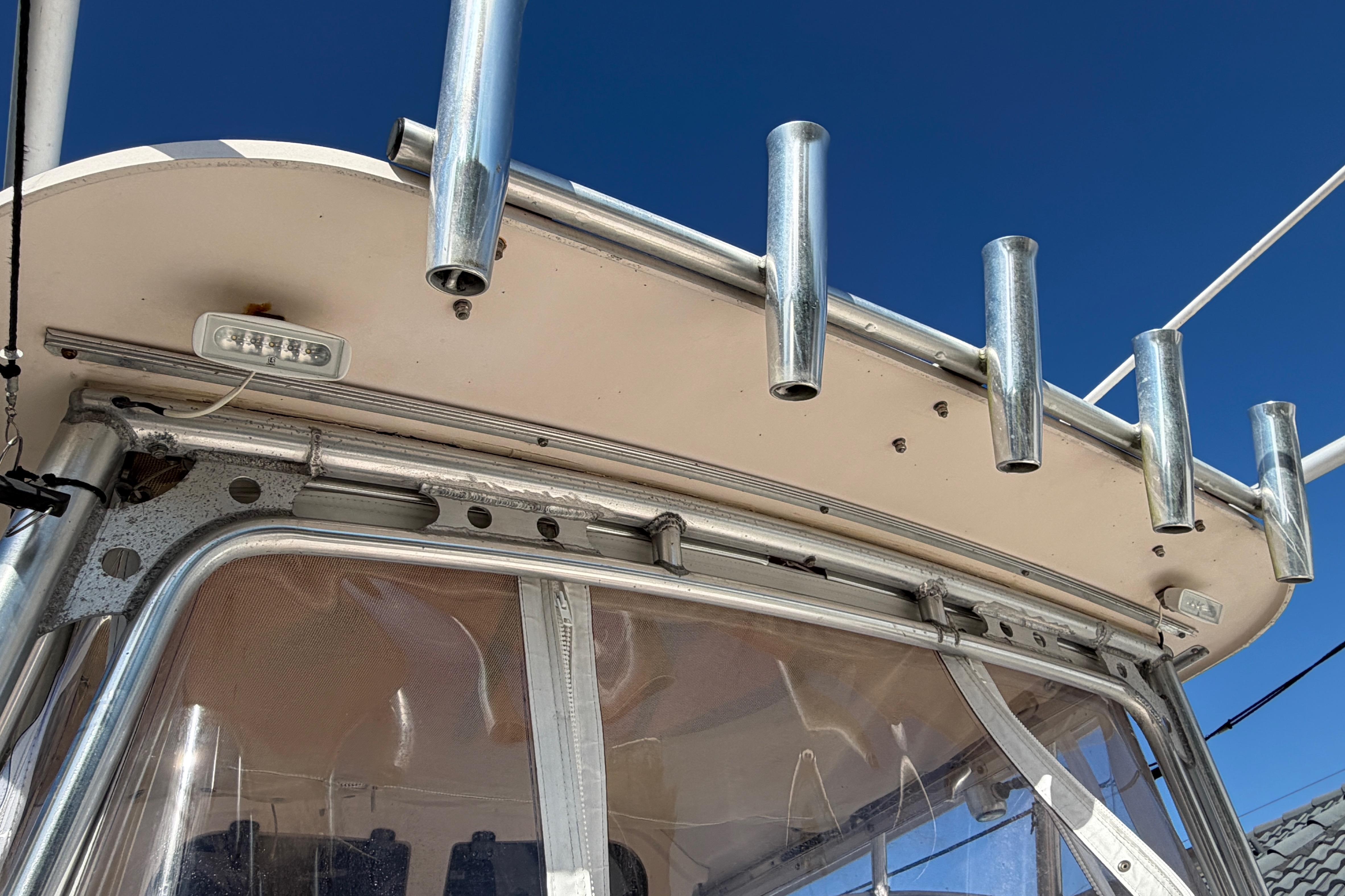 2006 Grady-White Sailfish 282 boat with rod holders and canopy against blue sky.