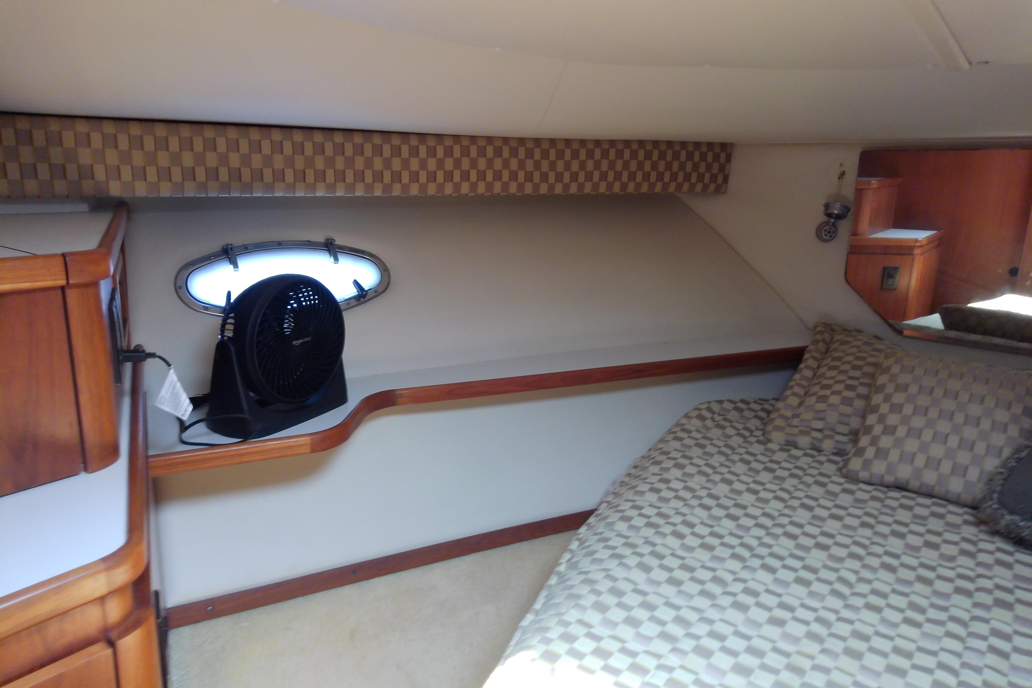 Cozy cabin interior of 2000 Tiara Yachts 4100 Open with checkered bedding and wooden accents.