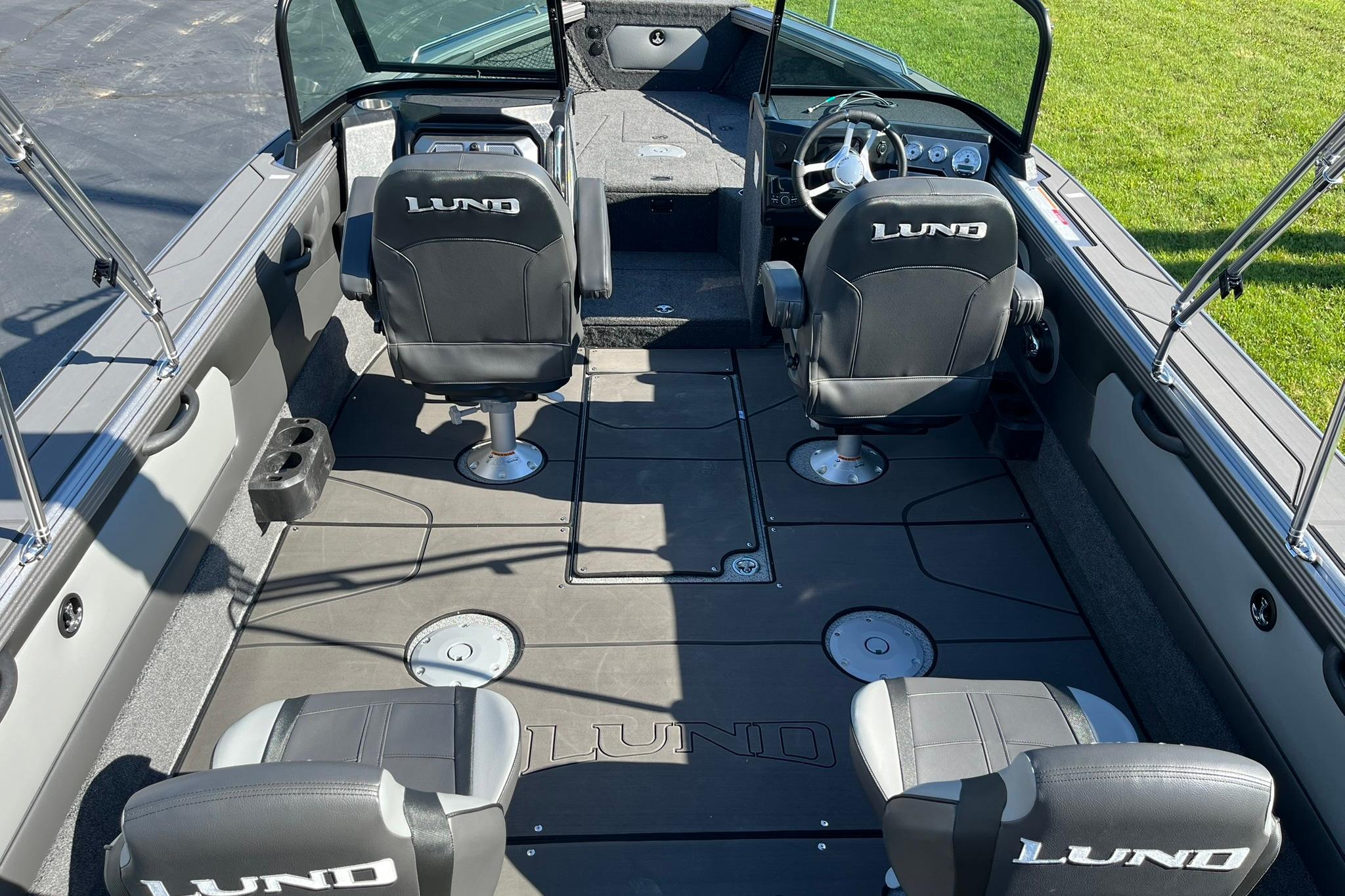 2026 Lund 2275 Baron boat interior with four seats and steering console.