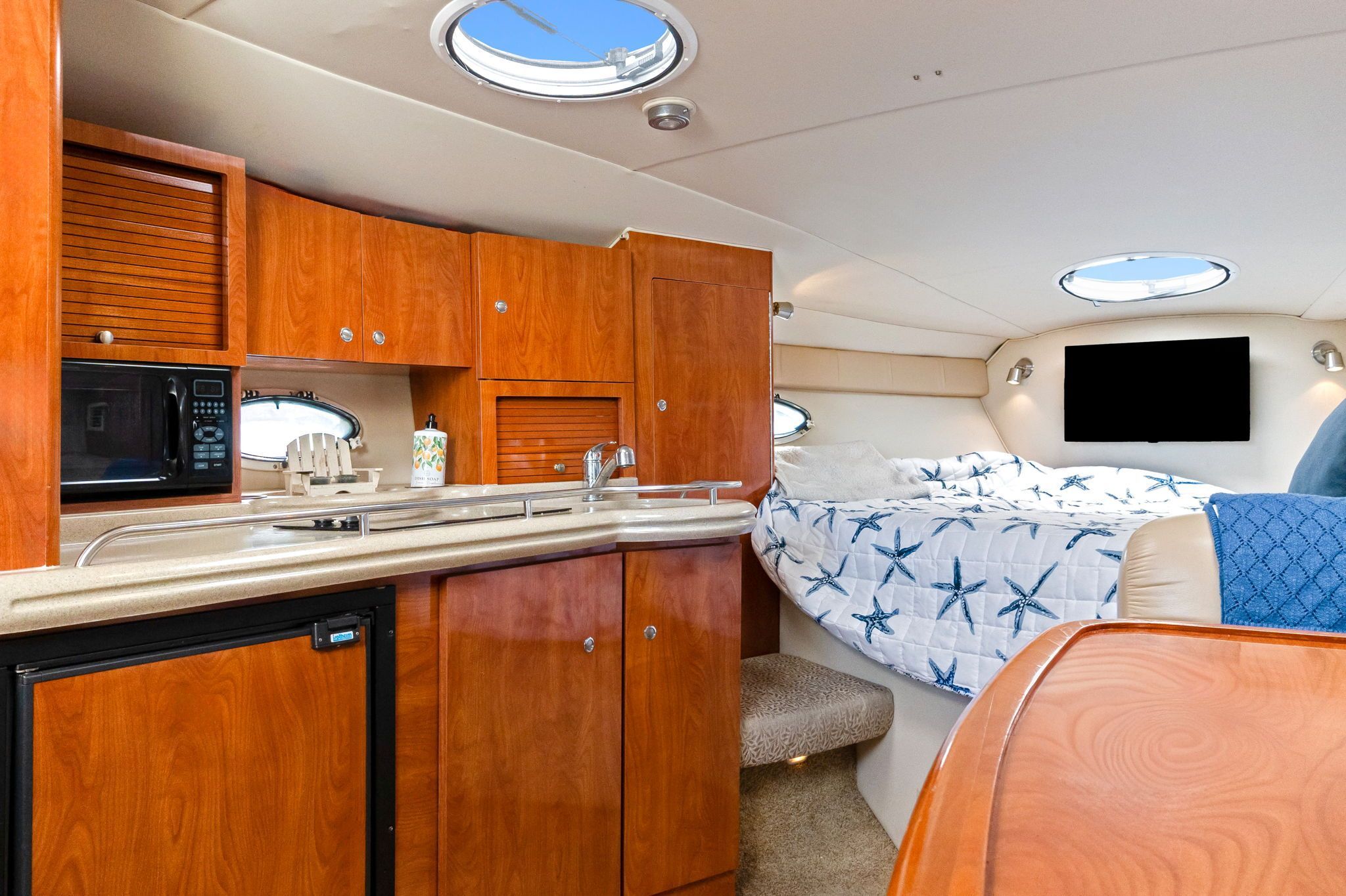 Interior of a 2007 Larson Cabrio 330 with kitchen and sleeping area.