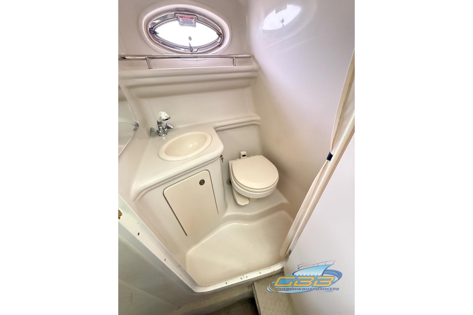 Compact bathroom in 2006 Sea Ray Sundancer 260 boat with sink and toilet.