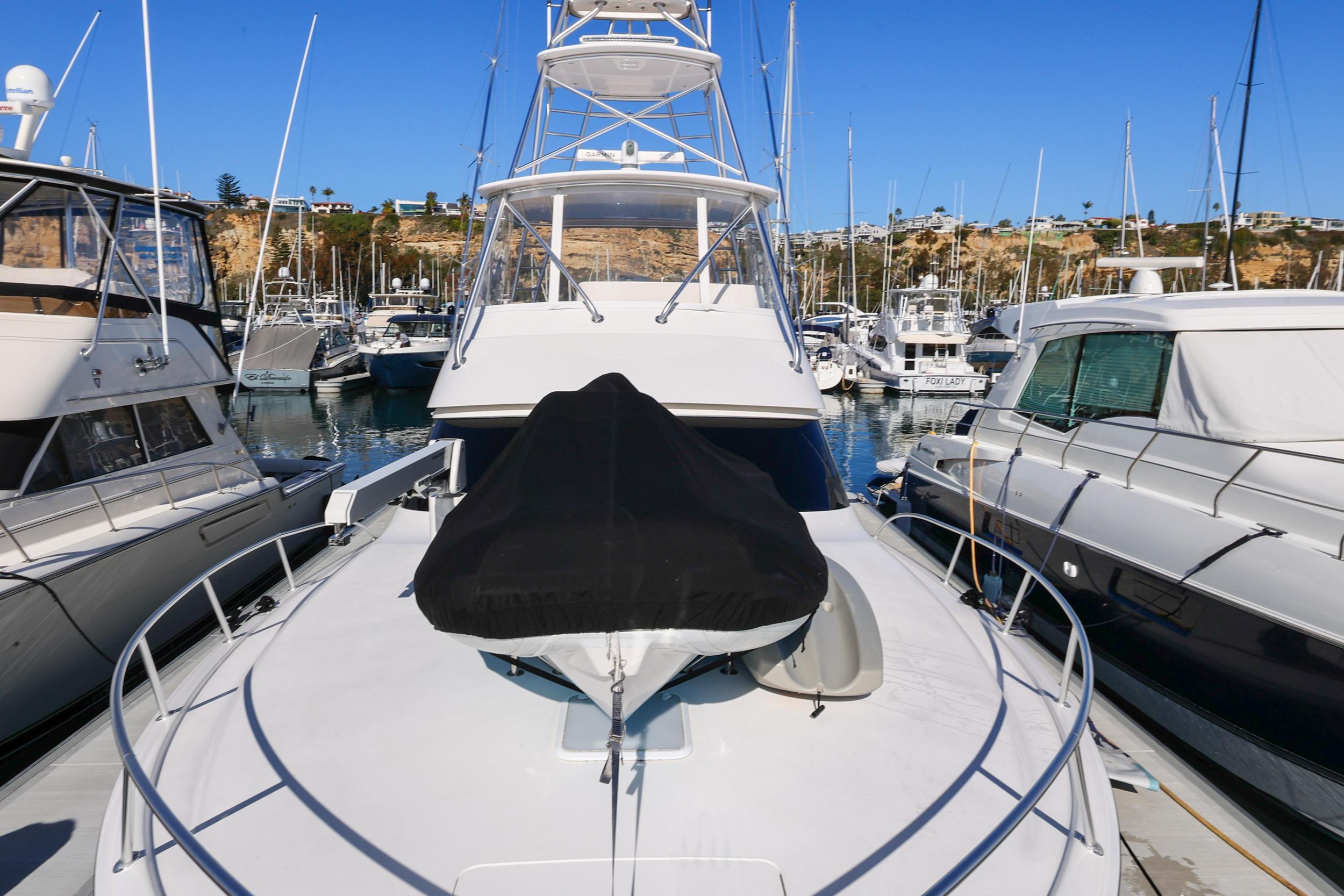 2013 Viking 46 Convertible yacht docked in a marina, surrounded by other boats.