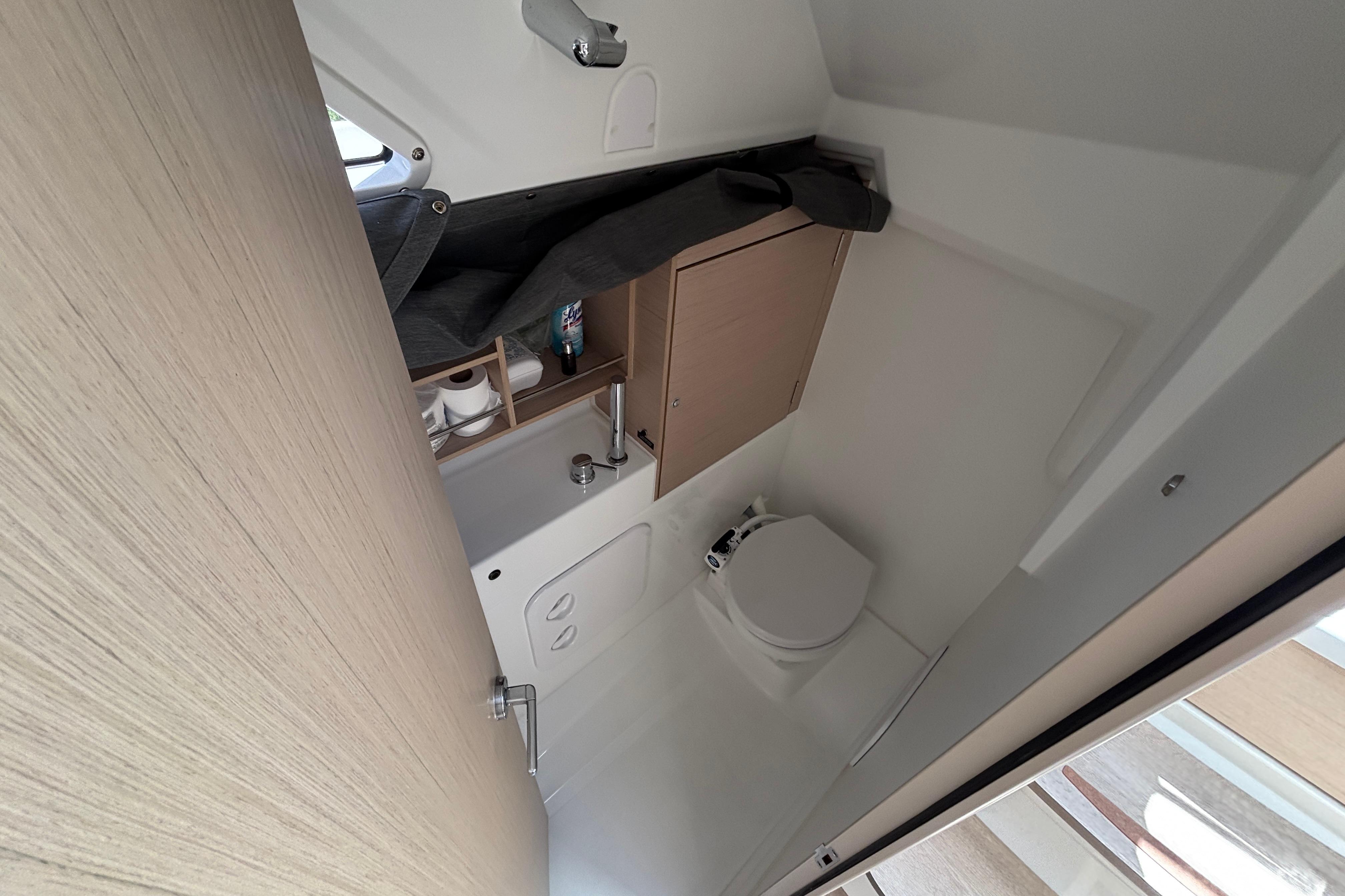 Interior of 2021 Beneteau Oceanis 30.1 yacht bathroom with compact design and storage.