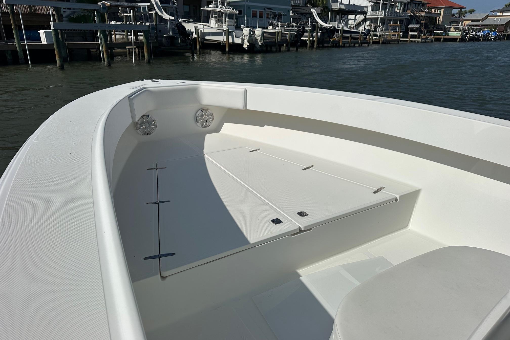 2003 Venture 34 Center Console boat interior with seating and storage, docked by waterfront homes.